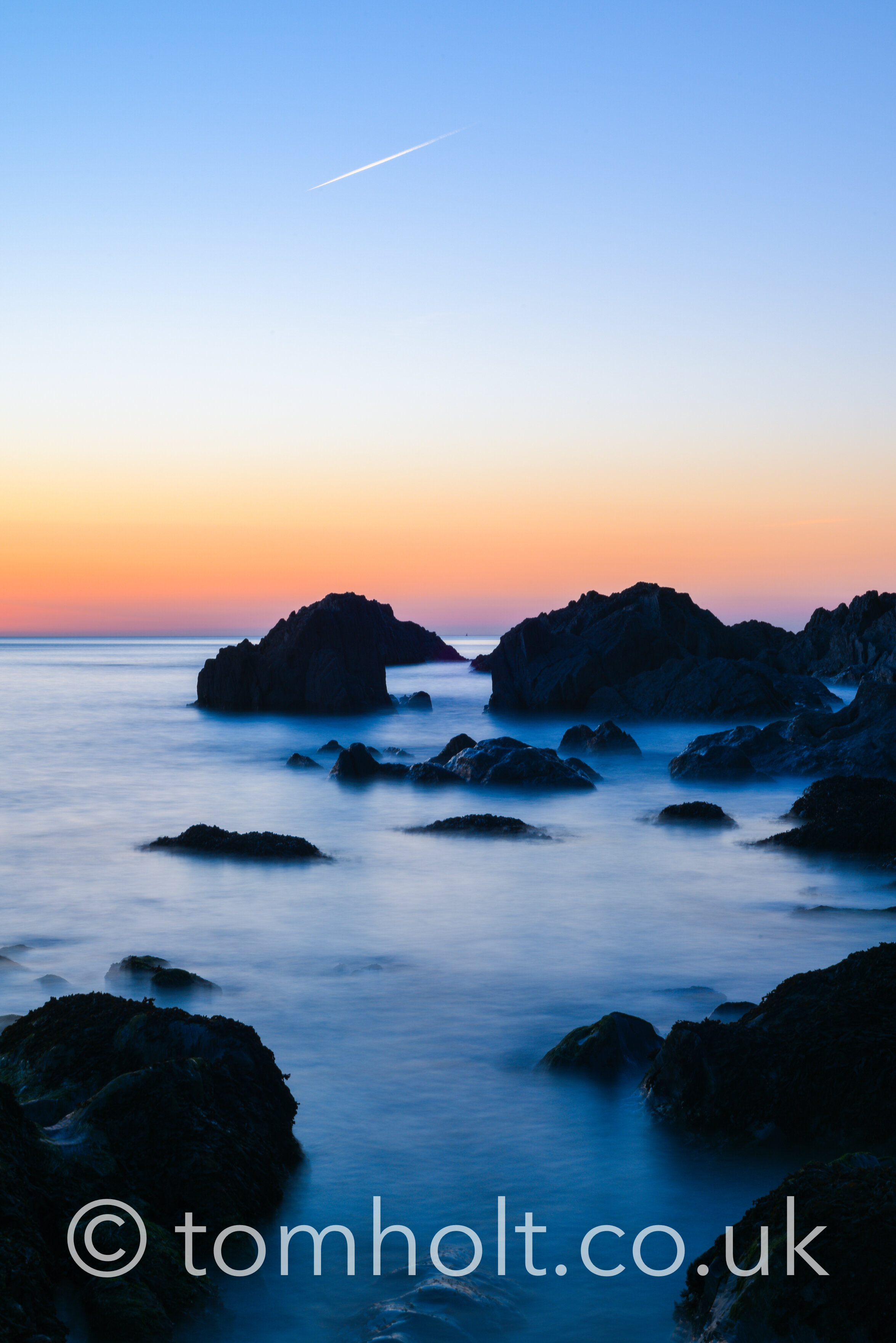 Relaxing sunset view of the sea in slow shutter over rocks