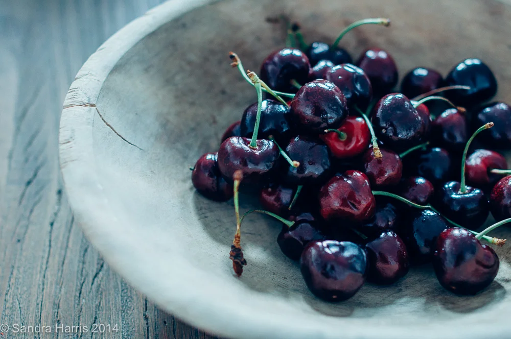 bing cherries in a vintage wooden bowl - Sandra Harris