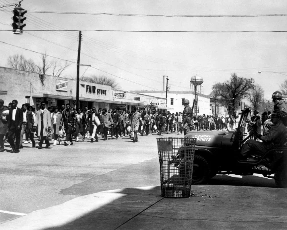 Federal guards watch as marchers make their way through the third leg of the Selma to Montgomery march. The number of marchers had swelled to over 25,000 people by the time they reached Montgomery.