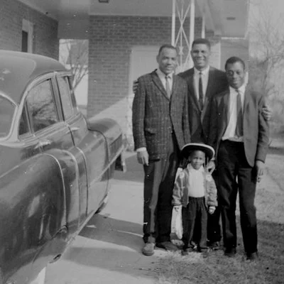 Evers (center) embracing Meredith (left) and iconic writer James Baldwin (right), who covered the Civil Rights Movement for magazines such as The New Yorker. Van Evers is the child in front .