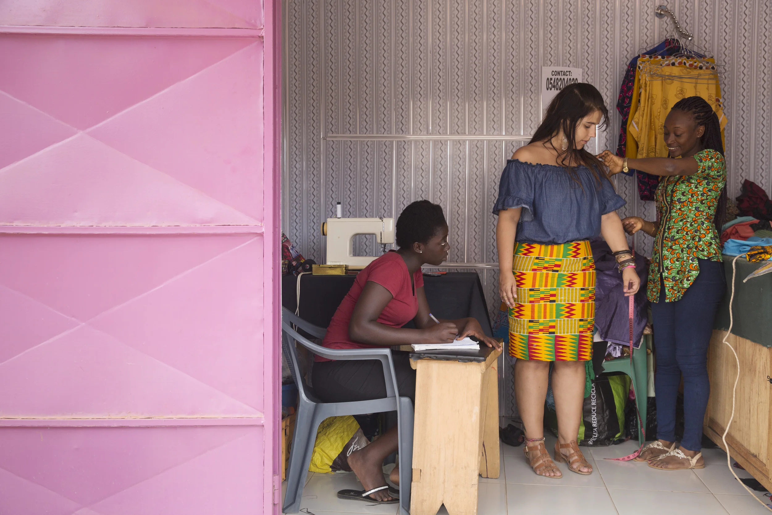 Mariana gets her measurements taken by the seamstress. 