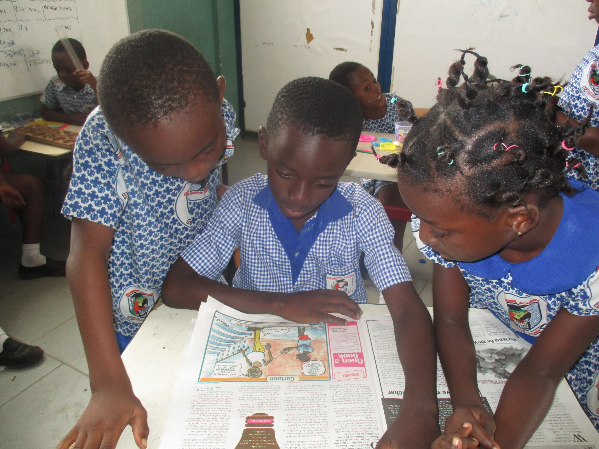 Students study a "graphic" (newspaper), by Alberta, Christiana, and Ruth, Class 6.