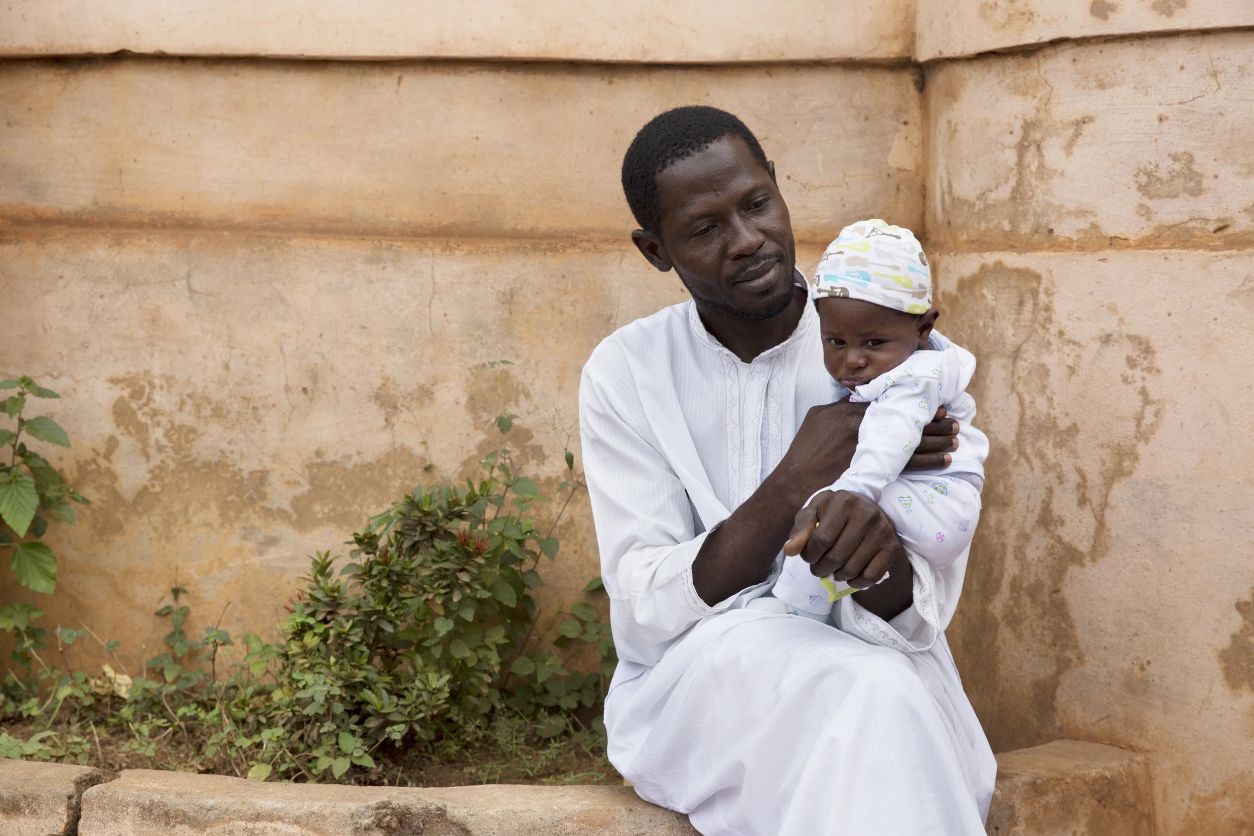 Eugenia's uncle sits with her new, three-month old cousin. 