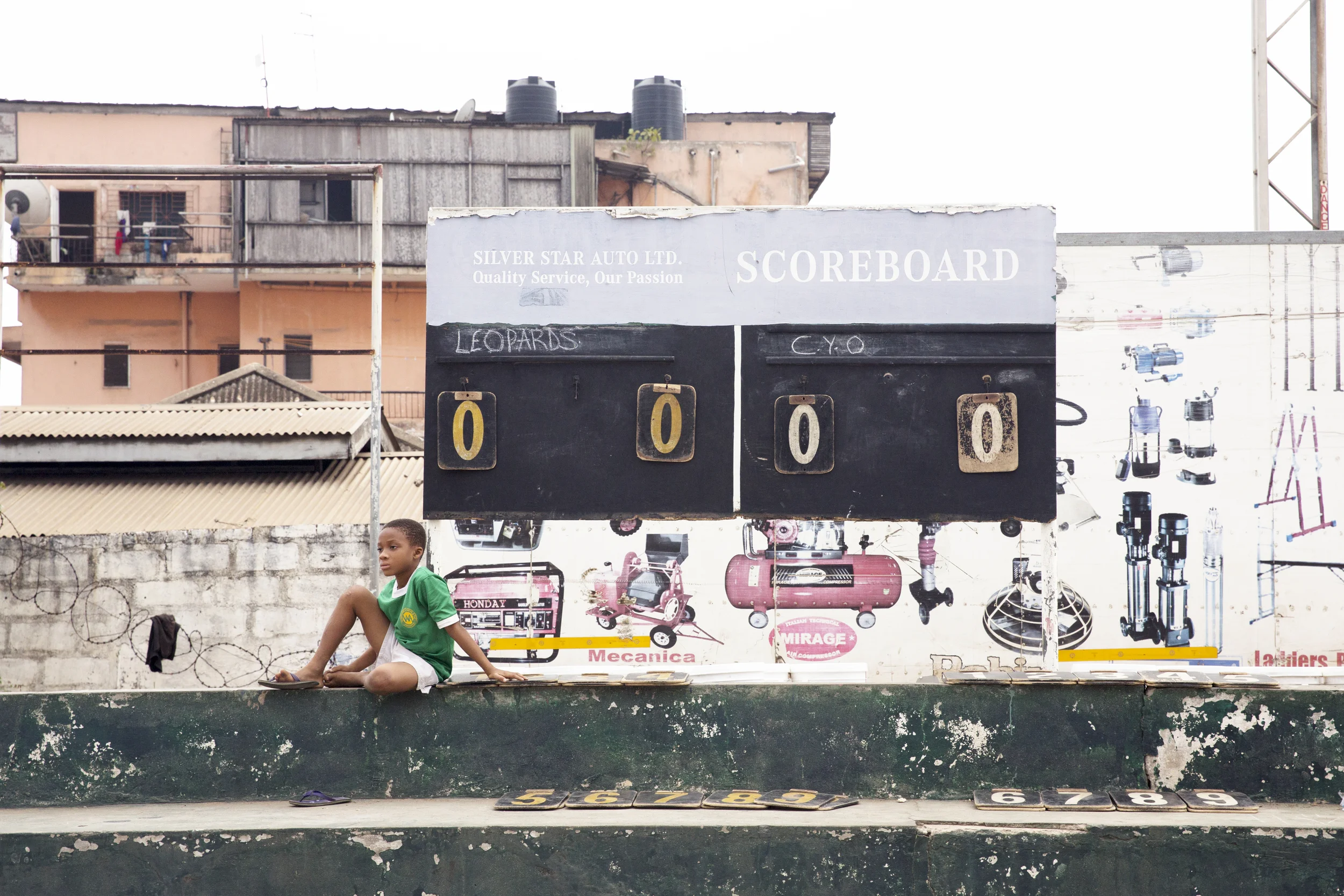 Though the referee had an electronic scoreboard set up on a table by the side of the court, local kids still maintained a manual scoreboard. 