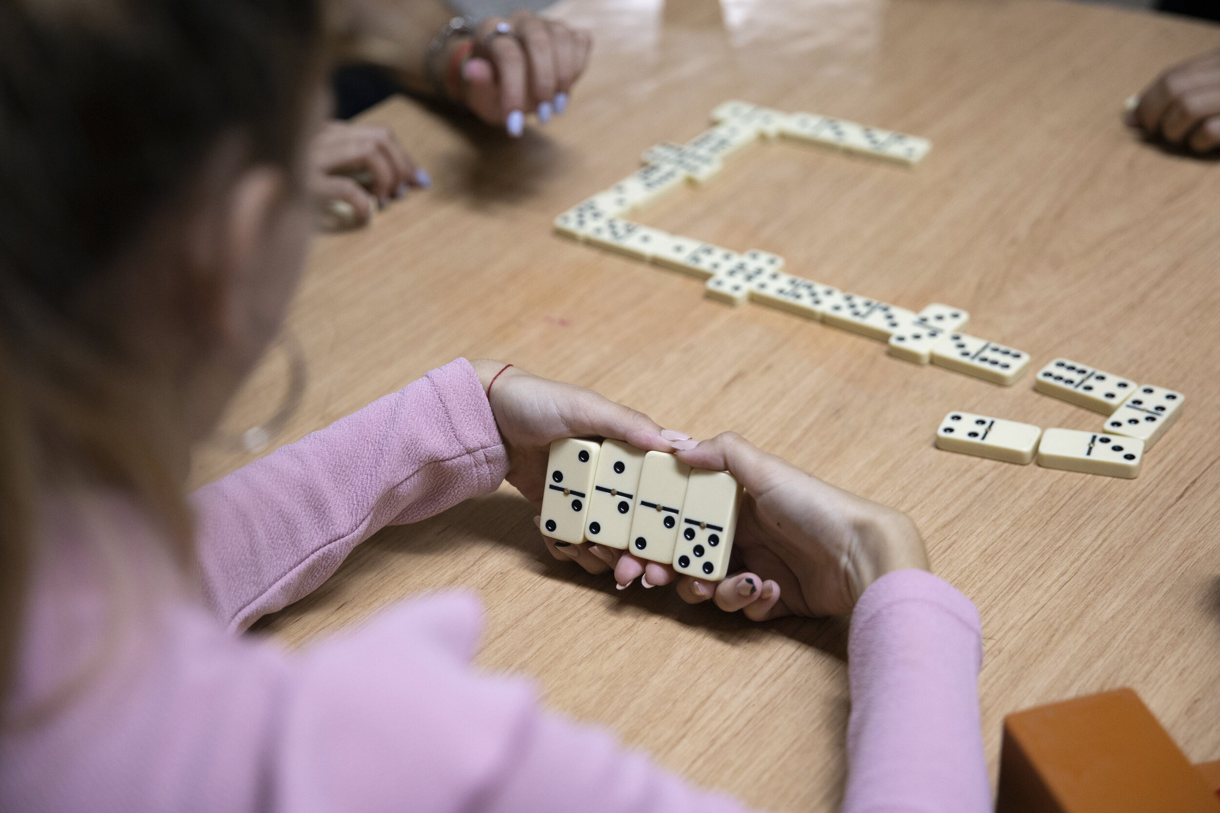  Adri plays dominoes with the other members of Beth Shalom’s youth group in the basement of the temple on January 18, 2020. When Quiñones was in her second year of pharmacy school at the University of Havana, she would travel an hour from her univers