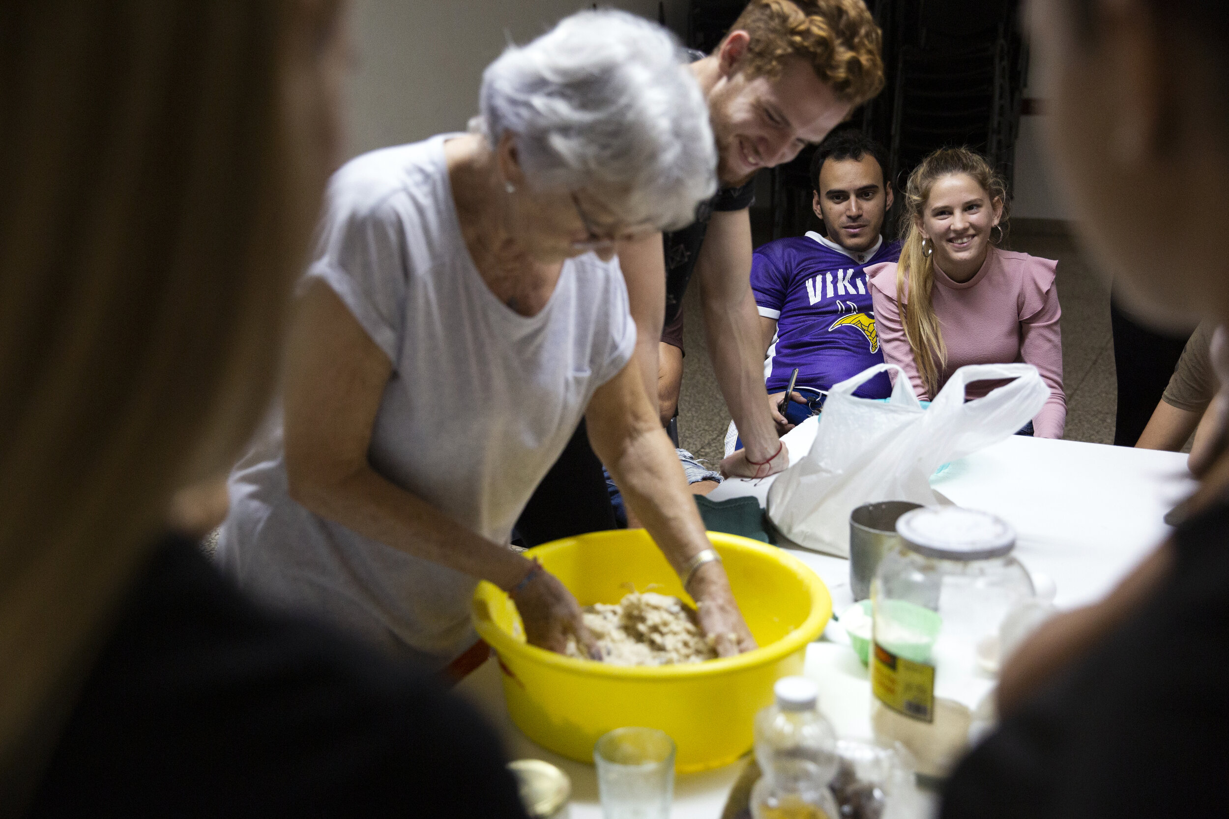  Ida (right), a synagogue elder, teachers the synagogue’s youth group how to make challah on January 18, 2020. 