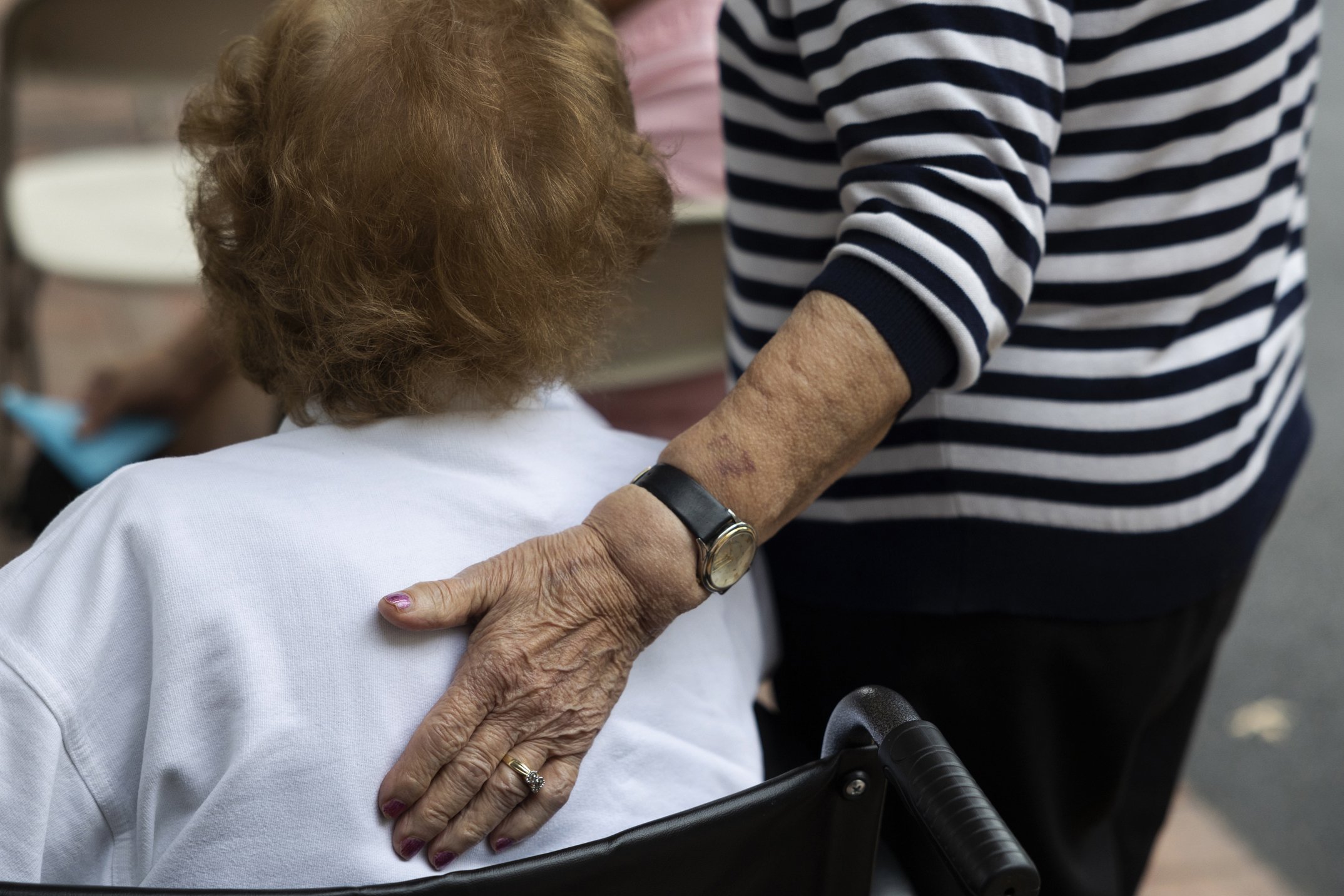   Pauline (right) places her hand on Mary’s back to comfort her after Mary gets emotional at the facility’s butterfly release memorial on September 16, 2021. 