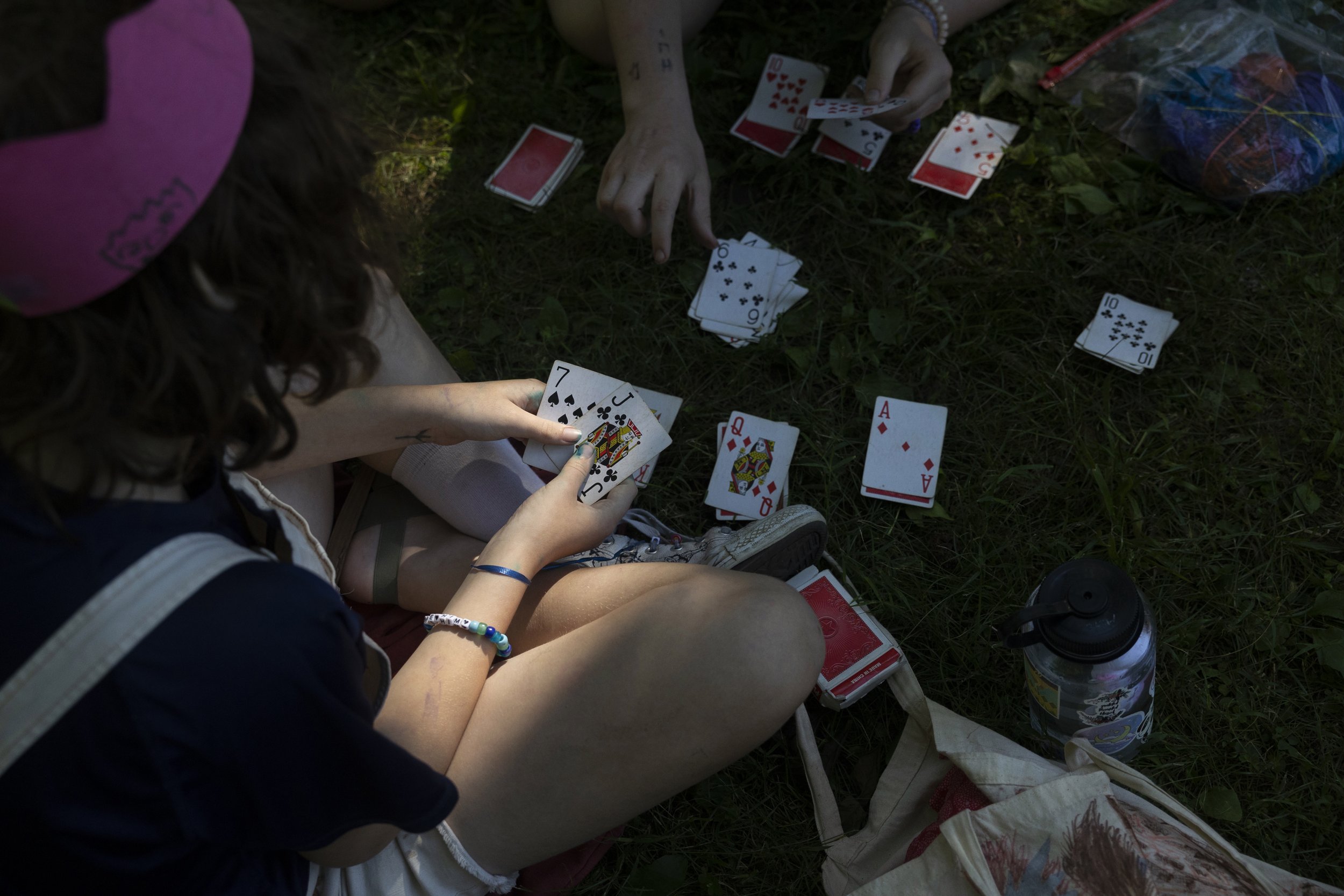  Campers Aster (left—he/they) and Ekho (she/her), who have become close over the week, play cards together on the last day of camp. 