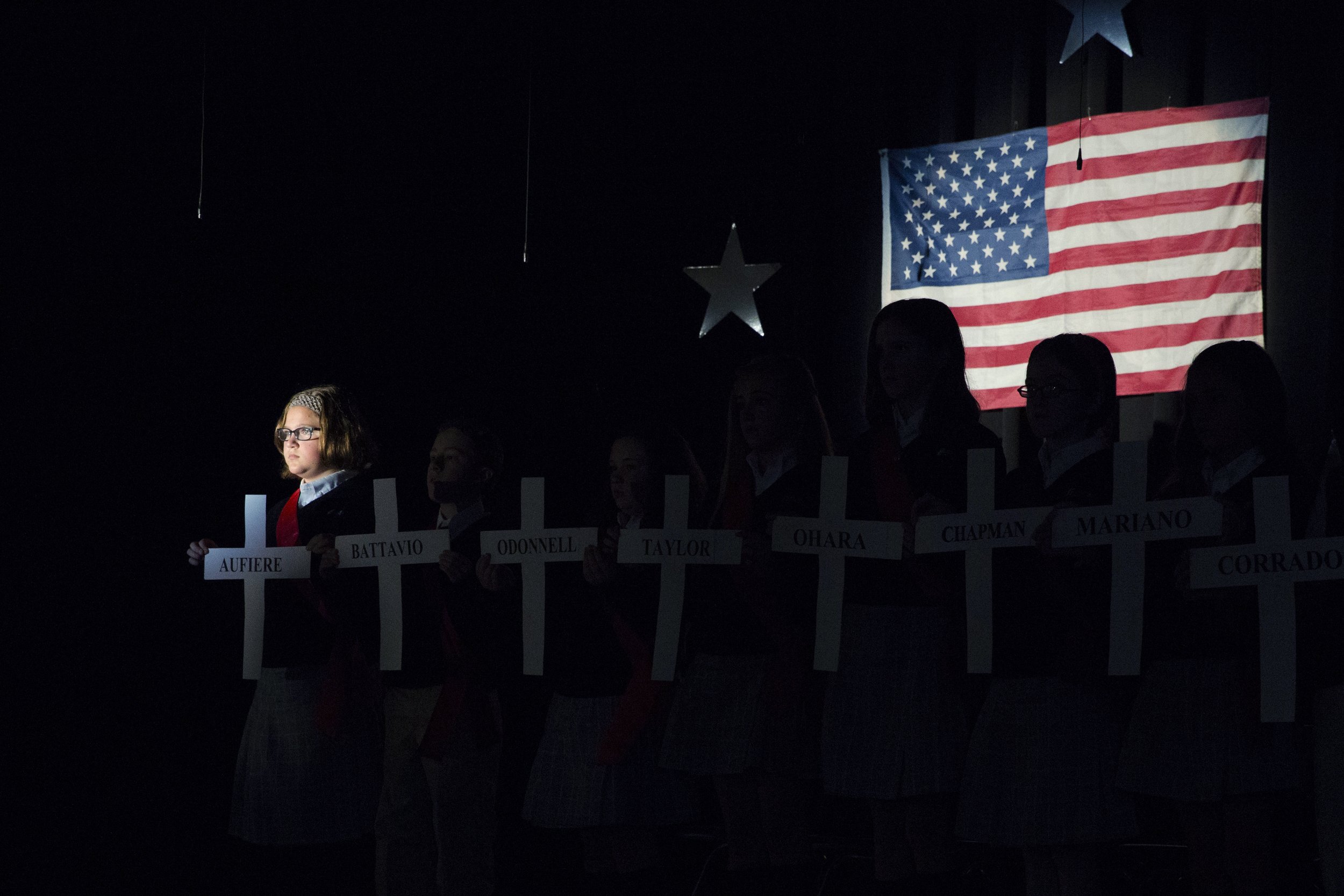  Sixth-grade students at Mater Dei Catholic School hold up crosses proclaiming the names of deceased servicemen whom are buried in the St. Stanislaus Parish Cemetery on November 11, 2016. (On assignment for Digital First Media) 