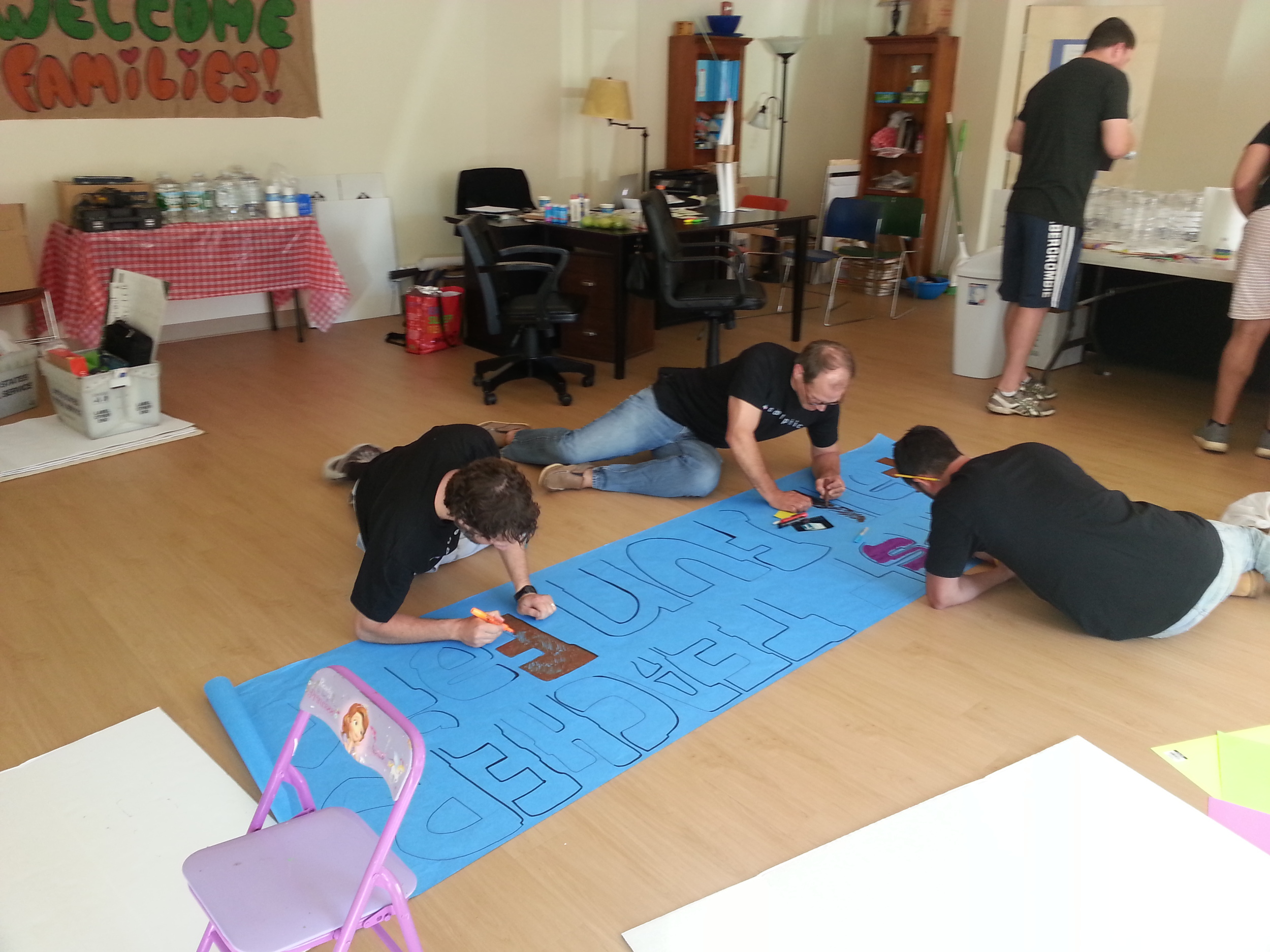 Volunteers from Adelphic Mobile help First Teacher prepare for a family oriented event to encourage parents to take an active role in their children's early education