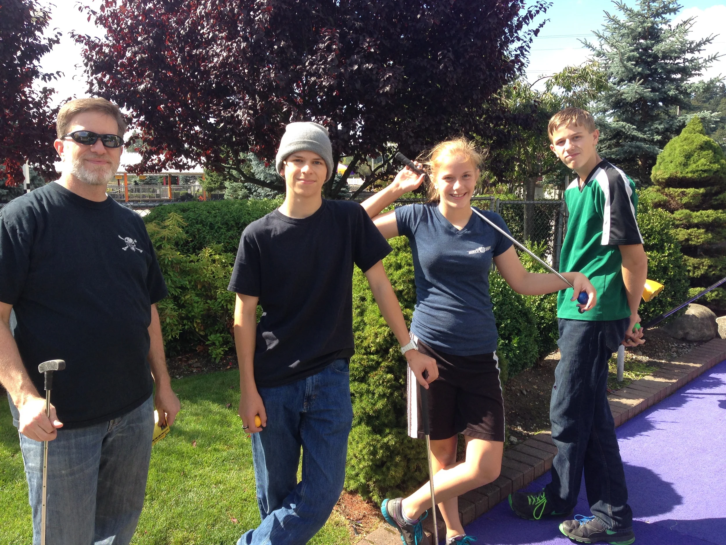 Steve, Matt, Jessie and Chris playing golf. 