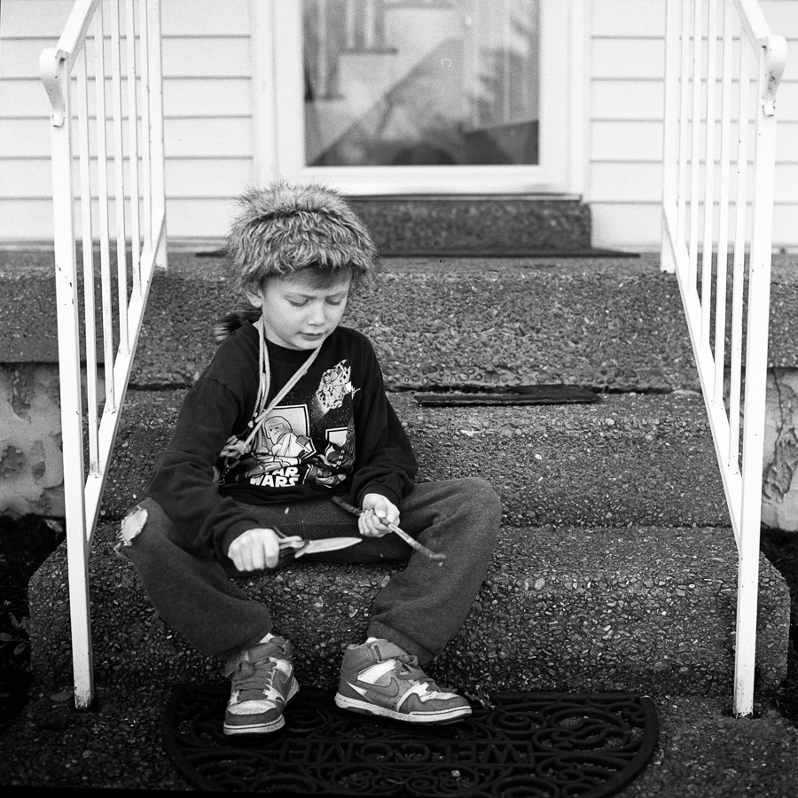 While Mommy and Grace we away, Jasper suddenly appeared in the front yard like this with his fur cap, pajamas, cardboard axe wrapped with duct tape, nature pouch, and pocket knife to "survive" in the neighborhood.