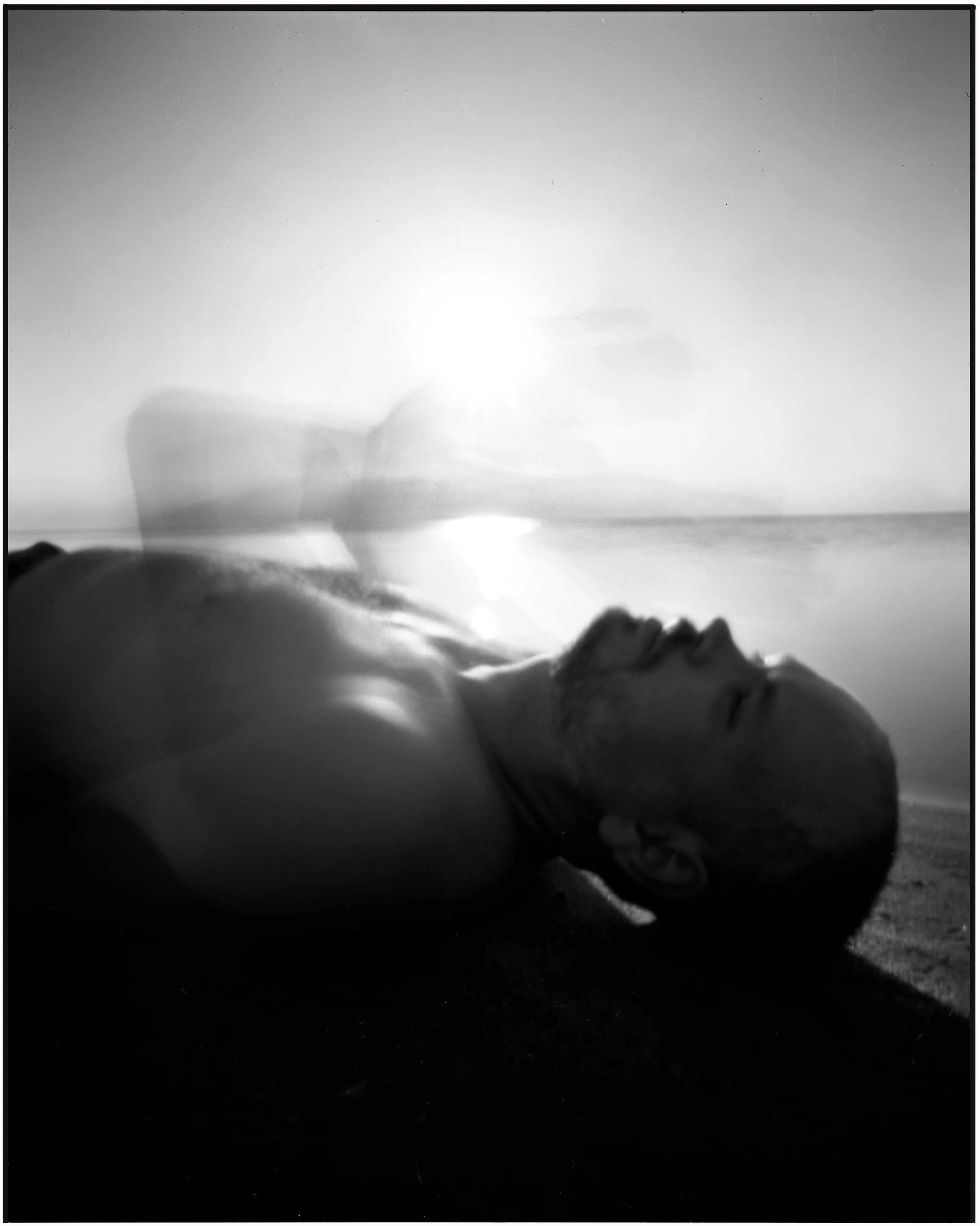My brother James was with me on this trip to the Sound. There were a couple of people hanging out in the water and in the sand. The light was beautiful so I put my pinhole camera on the tripod. When I laid in front of the camera James told me I was such a character. I told him I have been doing this so long I could care less what anyone thinks. I realized while he had seen lots of images I have made, he had rarely been around me while I making self portraits in public. I think someone might ask why didn't I just photograph him? I tried but its just easier to do it myself. By the time, i get someone to loose all the symbols on their clothes or direct them, it just seems simpler to do it myself. I like mystery in posed images and a big Nike symbol isn't going to cut it. But I never feel the same way about shooting a stranger on the street or do I? Maybe when I pick a person to photograph on the street I intuitively avoid those things. A 100 people may walk by that I have no interest in photographing. The self portraits gave me confidence and made me accept my appearance. I have made as many bad photos of myself as good and I never wanted images of me to look like a Idealized colonial painting or something from Olan Mills. I want people to feel something beyond thats pretty. At this point, with everyone doing profile pictures, Am I just doing a glorified Selfie that is better than yours?Or am I still exploring the self as a subject? I am guilty of using my images as profile pictures and I wonder if that in some way degrades the images? 