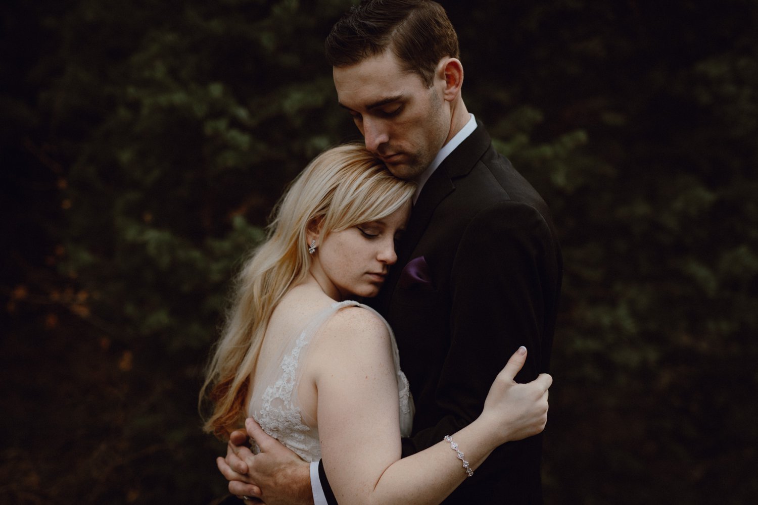A bride and groom embrace during their wedding portraits