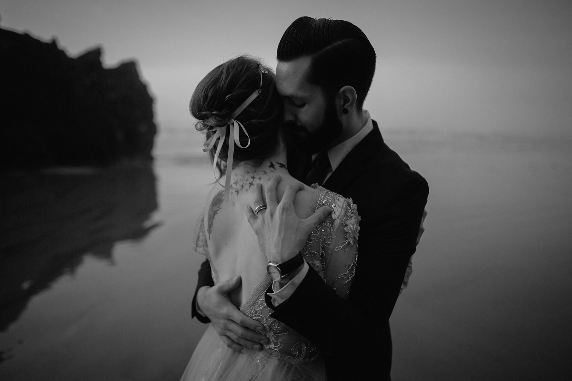A groom embraces his bride at this couple's Oregon Coast elopement.