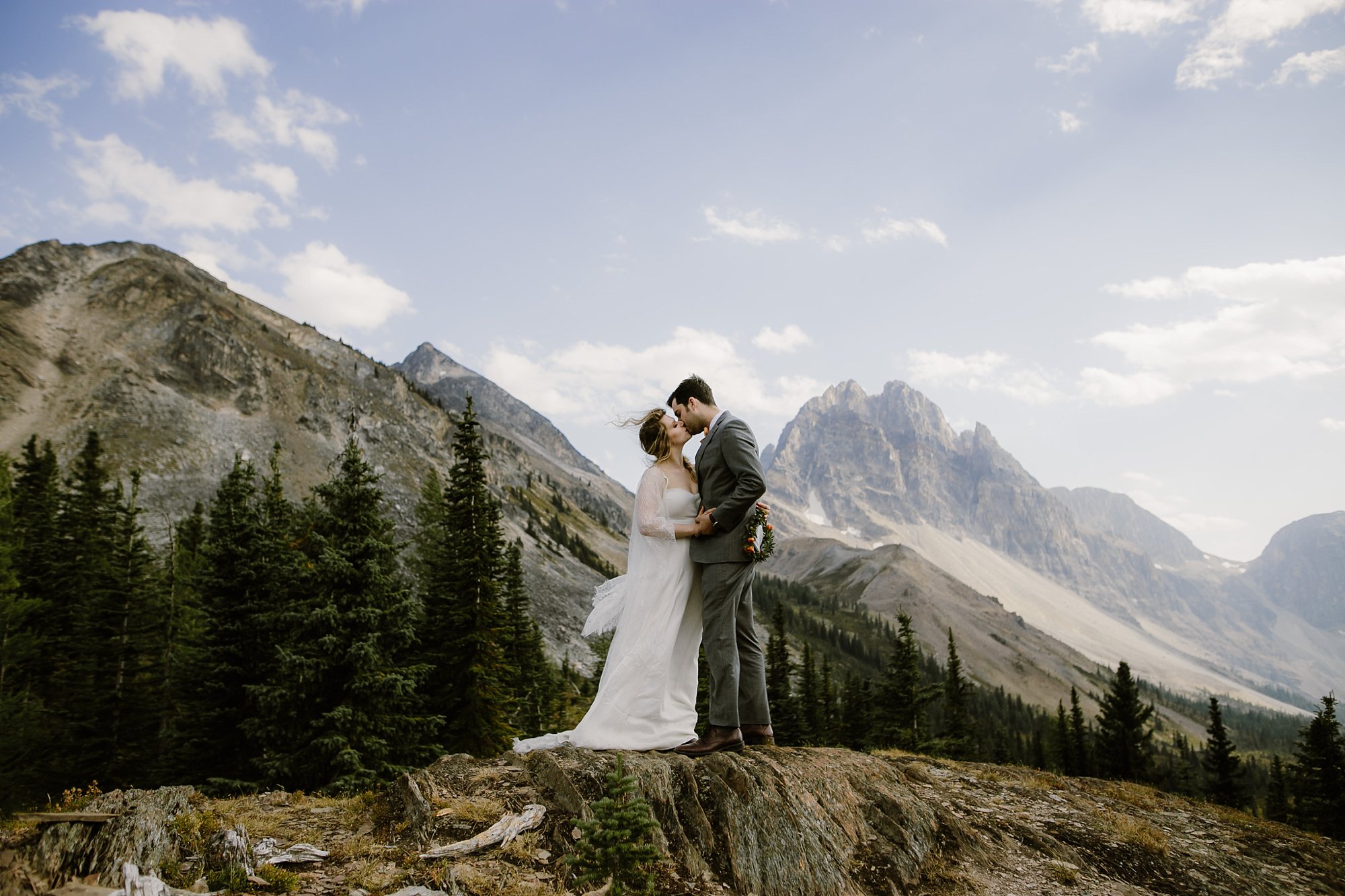 A bride and groom kiss during their helicopter adventure wedding