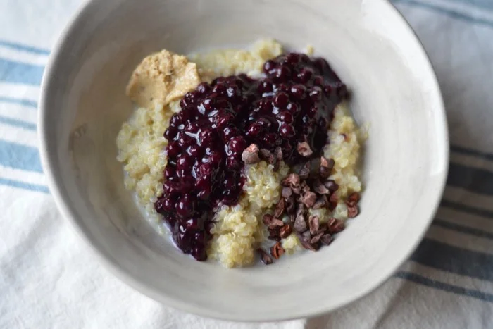 quinoa porridge with blueberry jam and cacao nibs