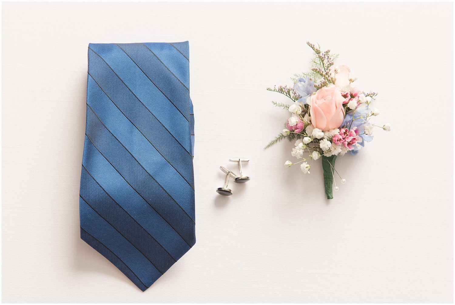 groom details blue striped tie and boutinner 