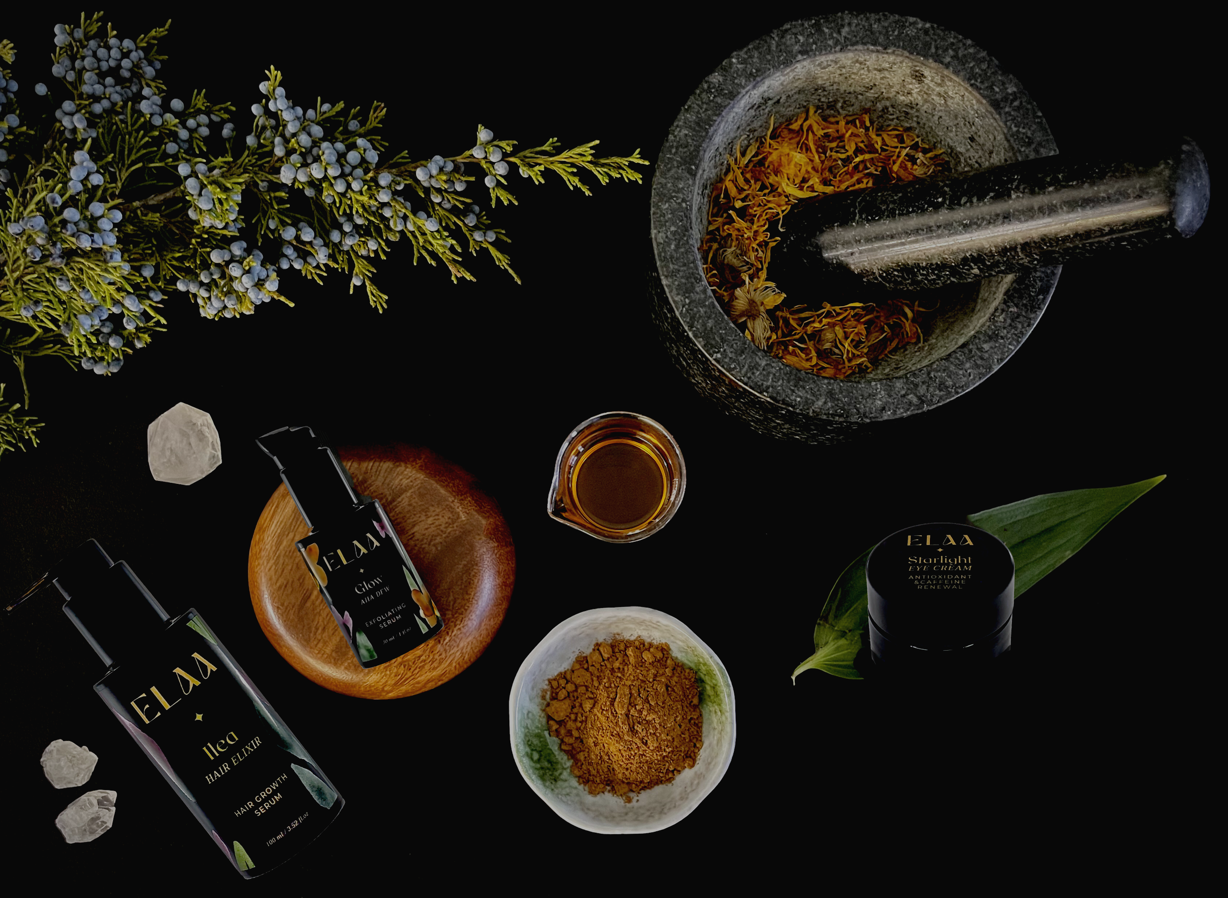 A bottle of ELAA Skincare Glazed Elixir Radiance Oil standing next to its packaging box, surrounded by flowers and petals with a textured green wall background.