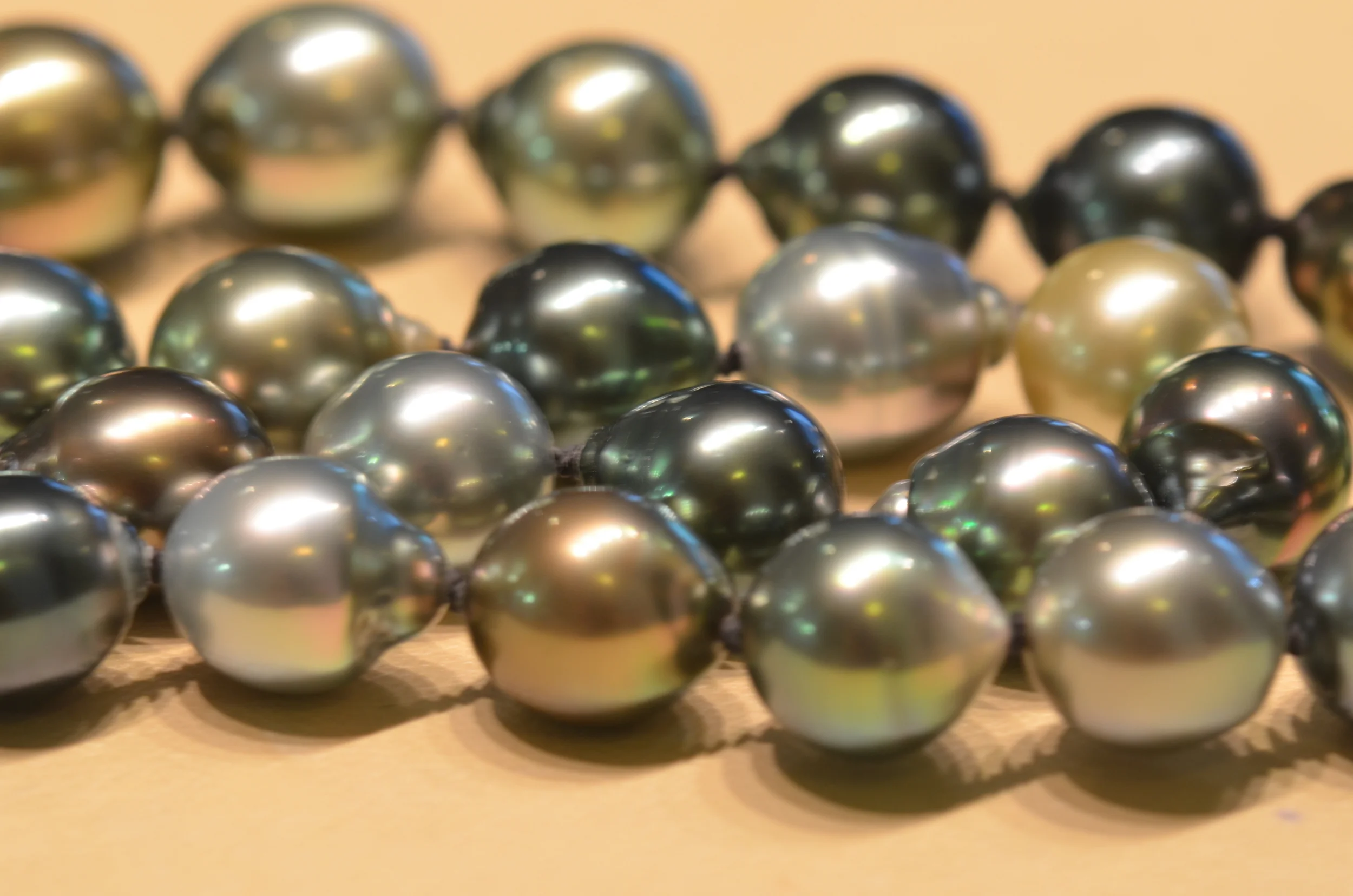 Organic splendor. A strand of Tahitian cultured pearls of various colors glistens in the light.
