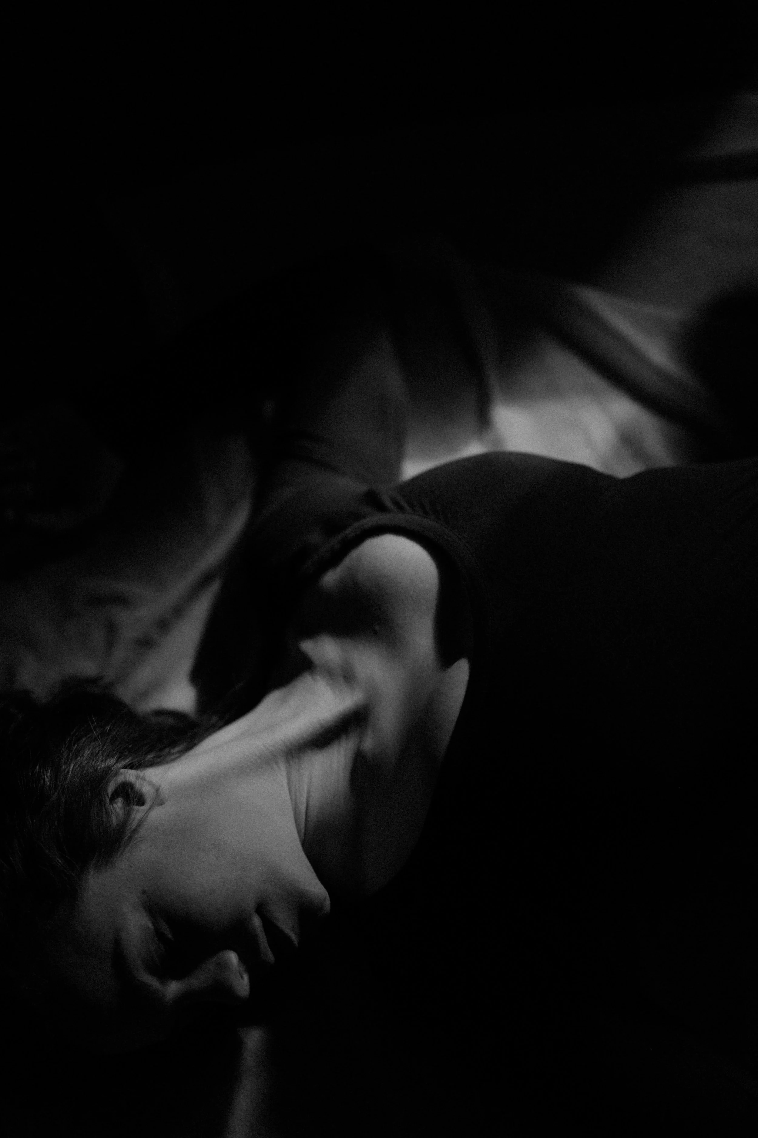 a black-and-white portrait of emma grimsley in a victorian airbnb in dayton, ohio. photograph by sarah rose walk of sarah rose photography. emma is laying in a sun spot on the ground, and she is looking to the side. emma is wearing a long sleeve burgundy red bodysuit.