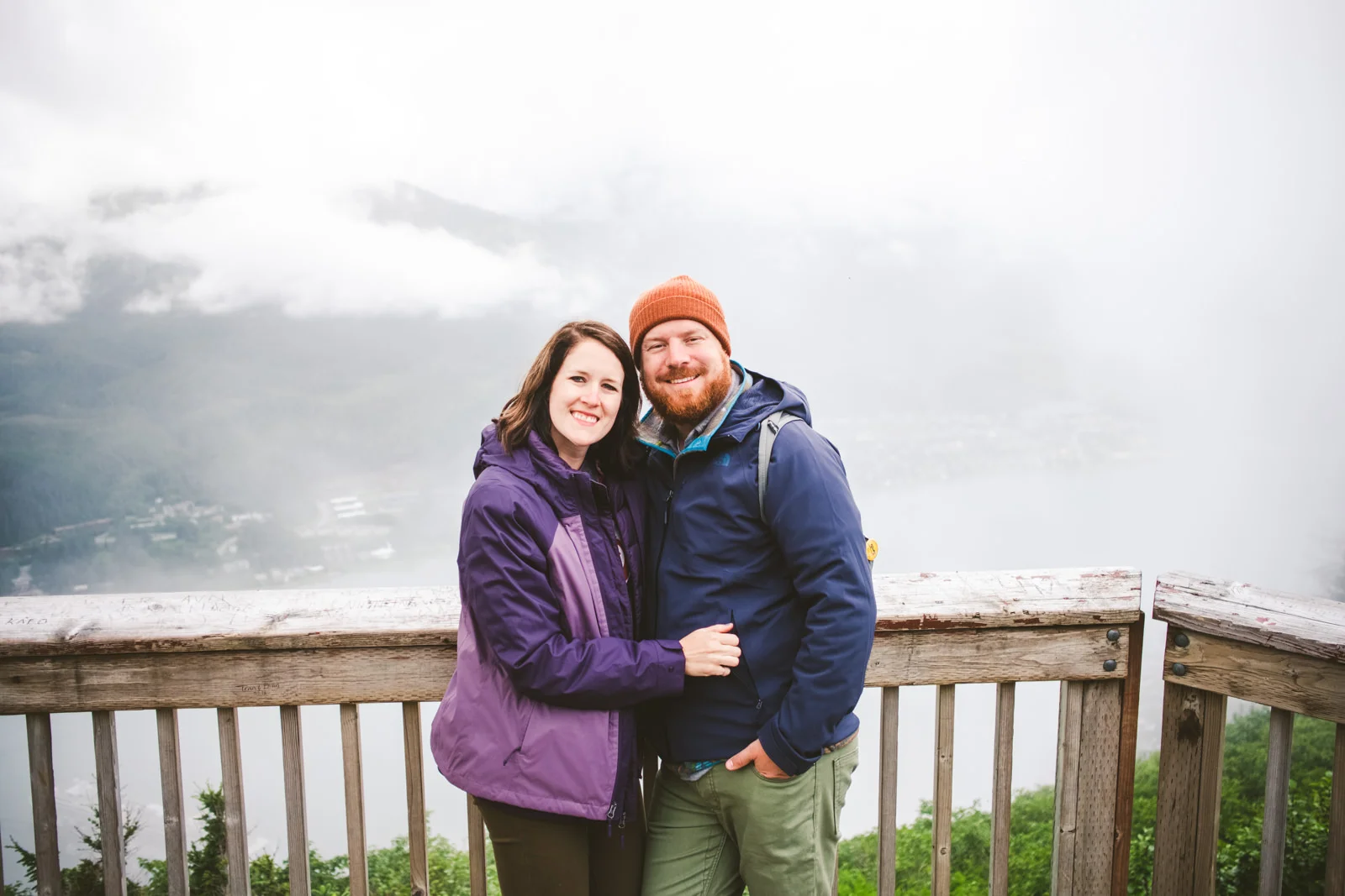 destination wedding photographers pose together in front of mountain 