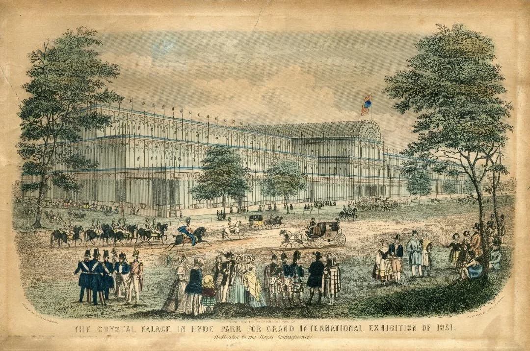 An 1851 print depicting the Crystal Palace in Hyde Park. The artwork shows regency ladies and gentlemen t strolling the grounds of the Grand International exhibition, along with horses and carriages traveling in the street.