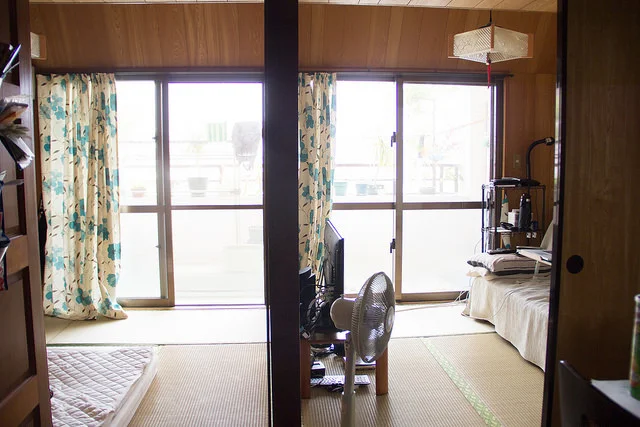 View of the two tatami rooms and the moveable barrier between them. You could open up the sliding wooden doors in the middle and have one big room, or you can separate them into 2 rooms. Note the tatami mats on the floor.