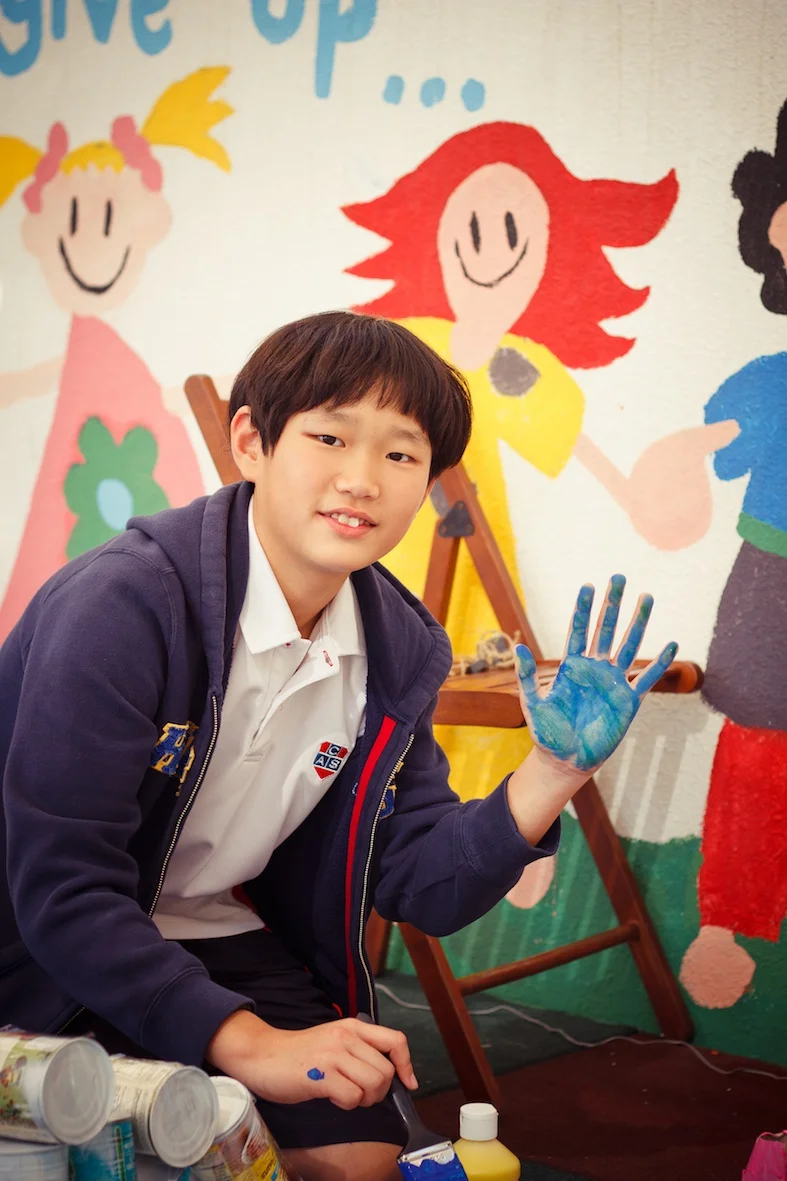 Daniel getting ready to slap some handprints on his robot superhero.