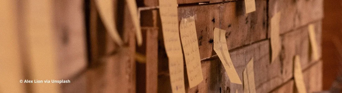 Holzwand mit gelben Post-its