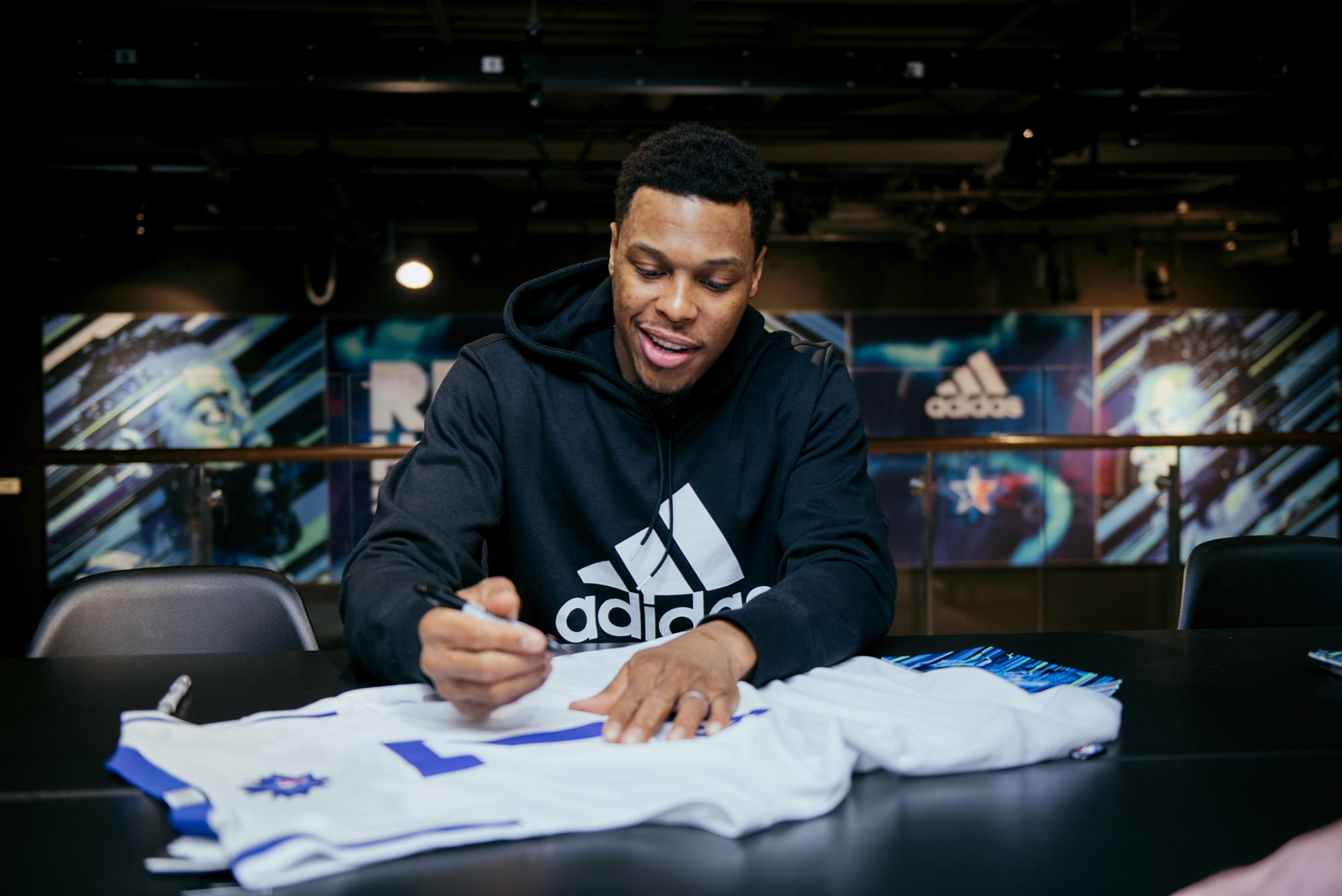 Kyle Lowry of the Toronto Raptors signs jerseys at the adidas flagship store in downtown Toronto. 