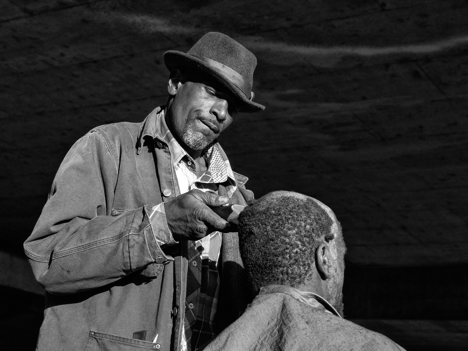 Gino "the barber" cutting his brothers hair in a homeless camp. Gino’s mother worked hard and held a job, but when he was born she was 13.