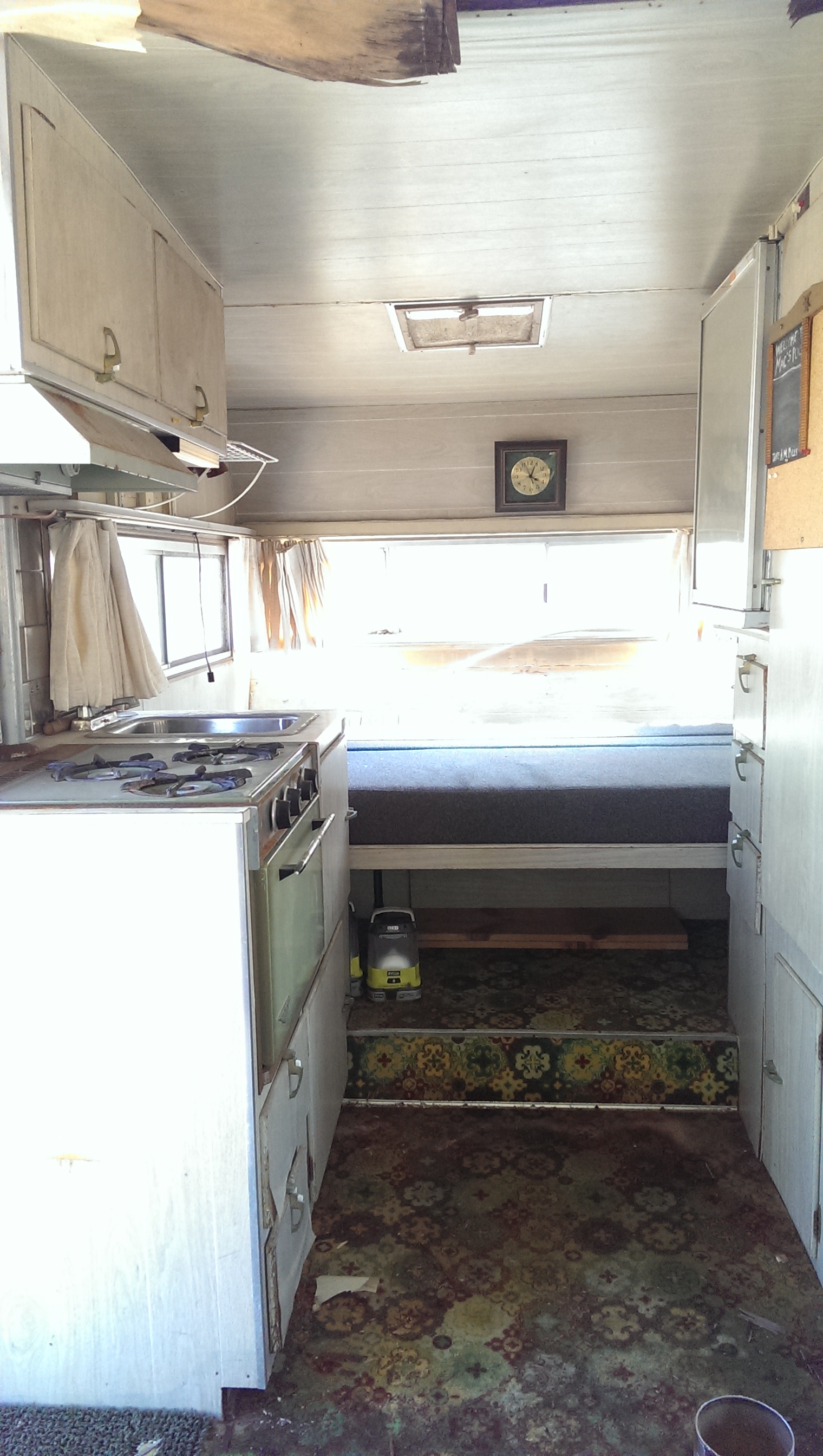 Here's where our bed will be; we will most likely tear out the whole kitchen area since we don't need it. You can see in this pic that the wood on the ceiling needs to be torn out and replaced, as do the skylights.