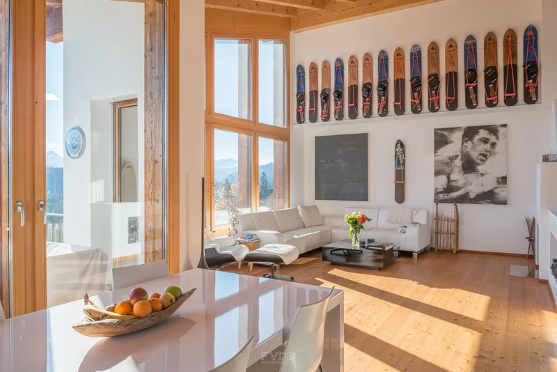 A vintage snowboard collection hangs amongst the art collection