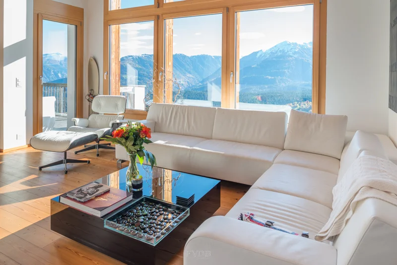 The high windows open the living room to a spectacular view of the mountains