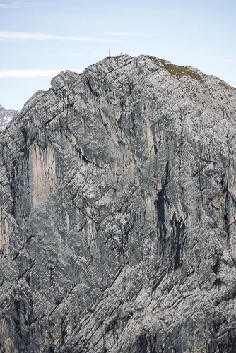 Three climbers stand atop the Bernadeinkopf which can be accessed as a bonus while returning from the Alpspitz Ferrata