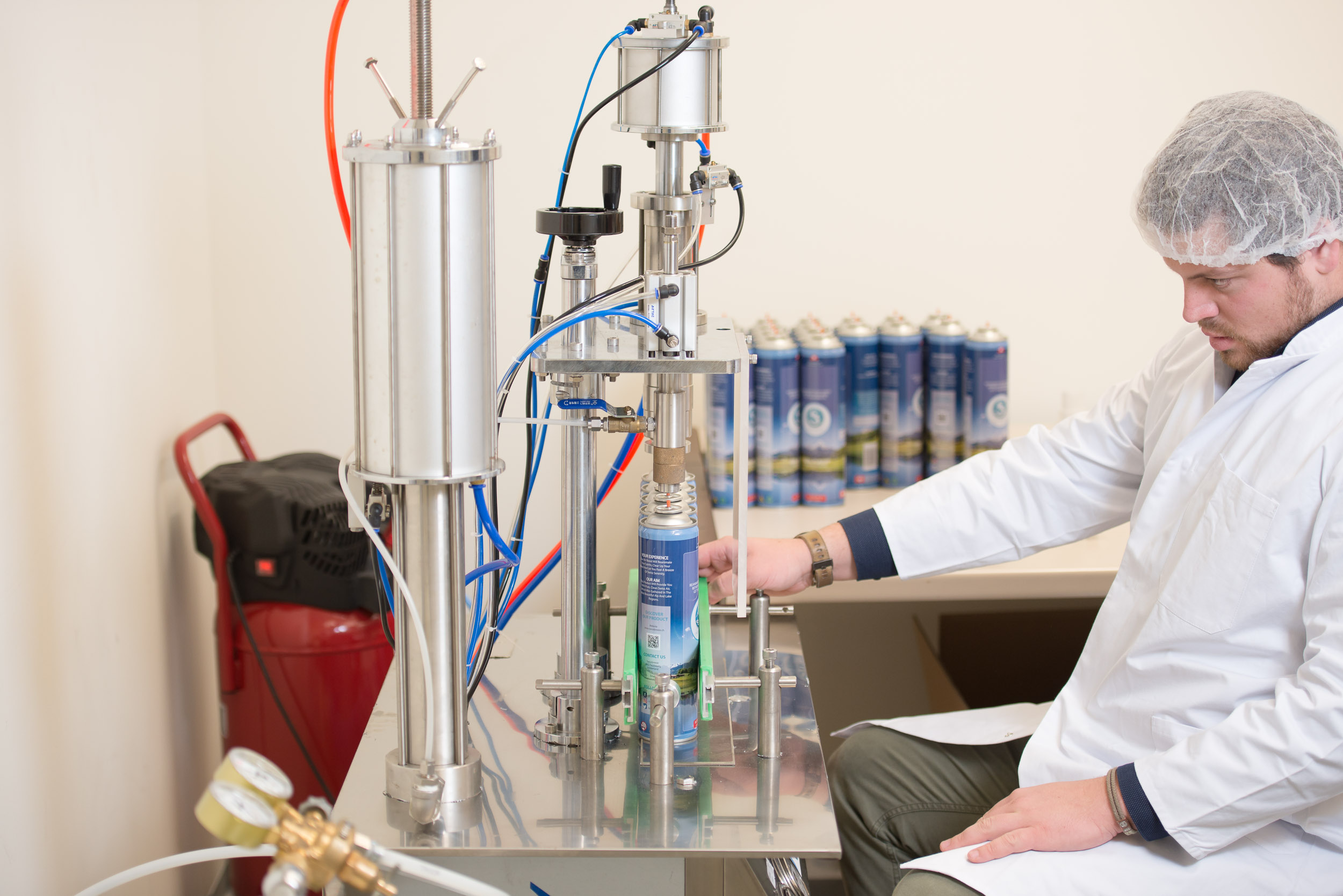 Moritz aligns the cans, preparing them for filling. In their small lab they can fill several hundred cans with air, but they outsource it to a large industrial partner in Basel which can complete the task far more efficiently.