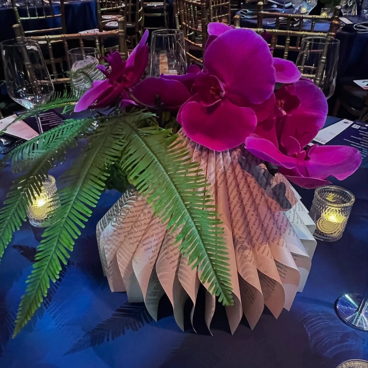 Grounded in pages, finished with orchids&mdash; World Book Day, but make it chic.🌺📕 

#eventplanner #eventprofs #nonprofitevents #nonprofiteventplanner #nyceventplanner #eventdesign #tablescape #candlelight #candles #decor #eventdecor #books #world
