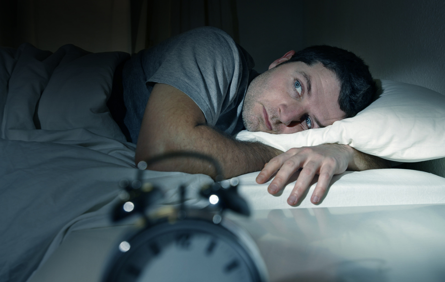man in bed with eyes opened suffering insomnia sleep disorder