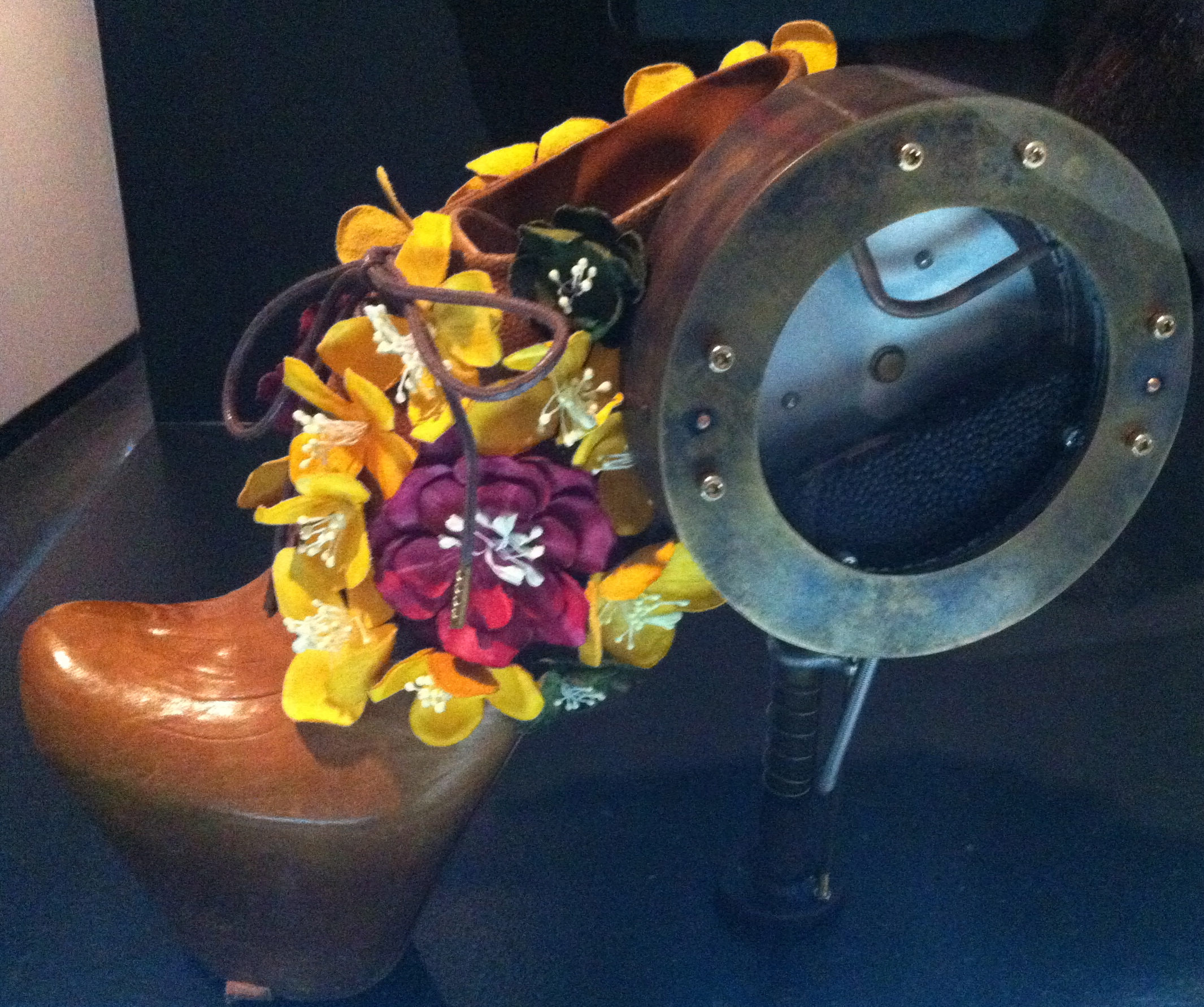 Healing Fukushima (Nanohana Heels) by artist and designer Sputniko! with shoe designer Masaya Kushino. Created in response to the 2011 Fukushima nuclear disaster, the seeds of the flowers on the shoe are known to absorb radioactive substances from the soil. As one walks, these seeds in the high heel are planted into the ground.