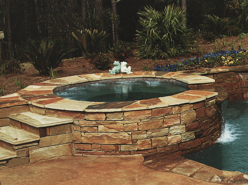 Raised spa wall with natural stone veneer and 6x6 waterline tile. Mosiac stone coping and Hydrazzo interior finish.