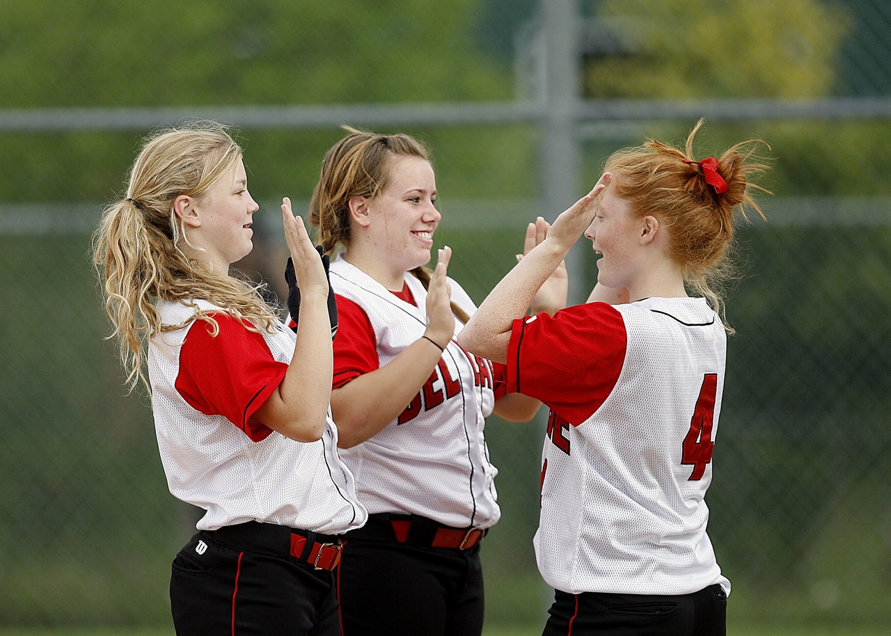 Teenage girls playing softball. Online Counseling sessions help busy teenagers get help for depression, anxiety and friend problems.