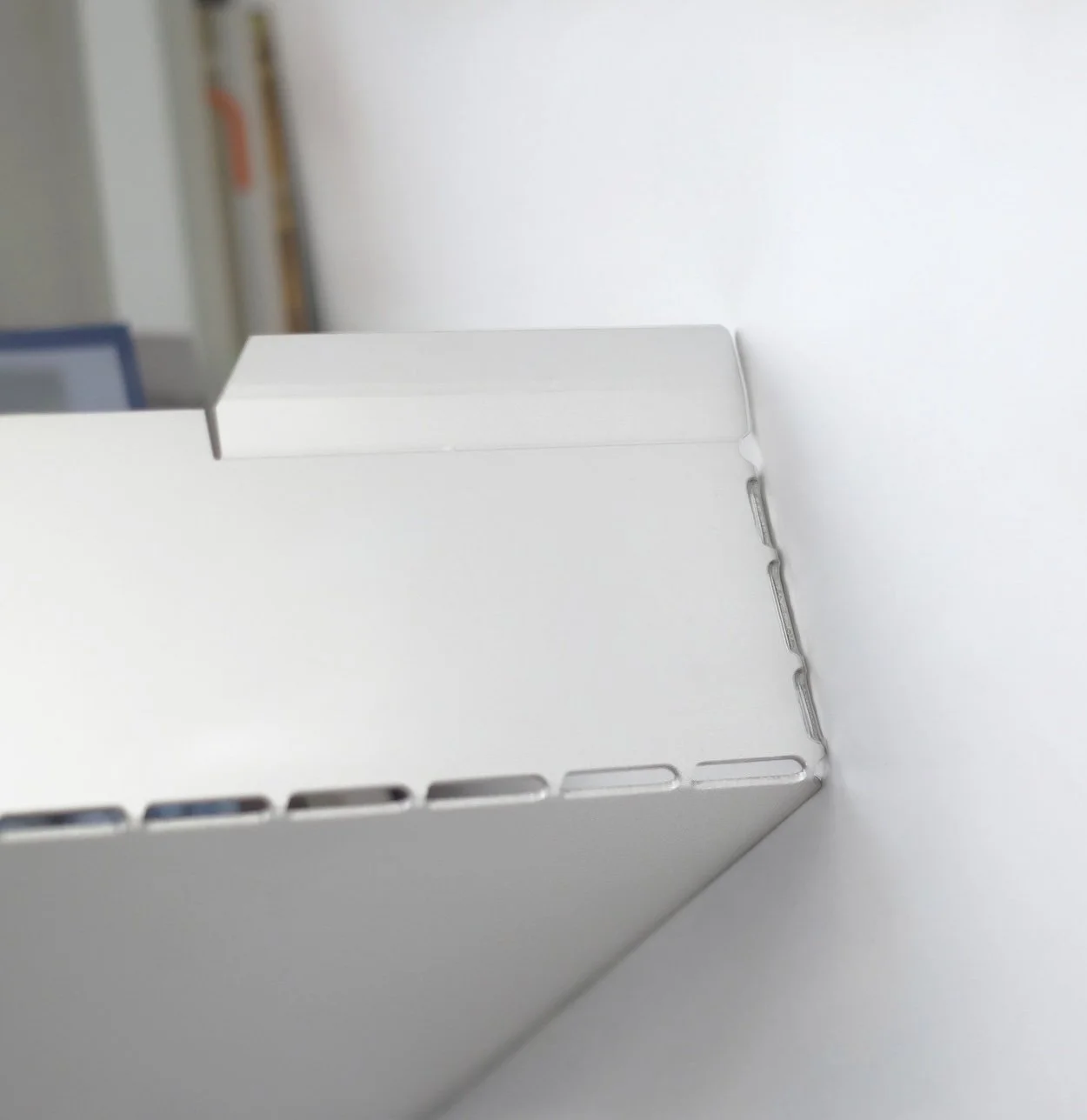 a wall shelf made from a single folded sheet of anodized aluminum