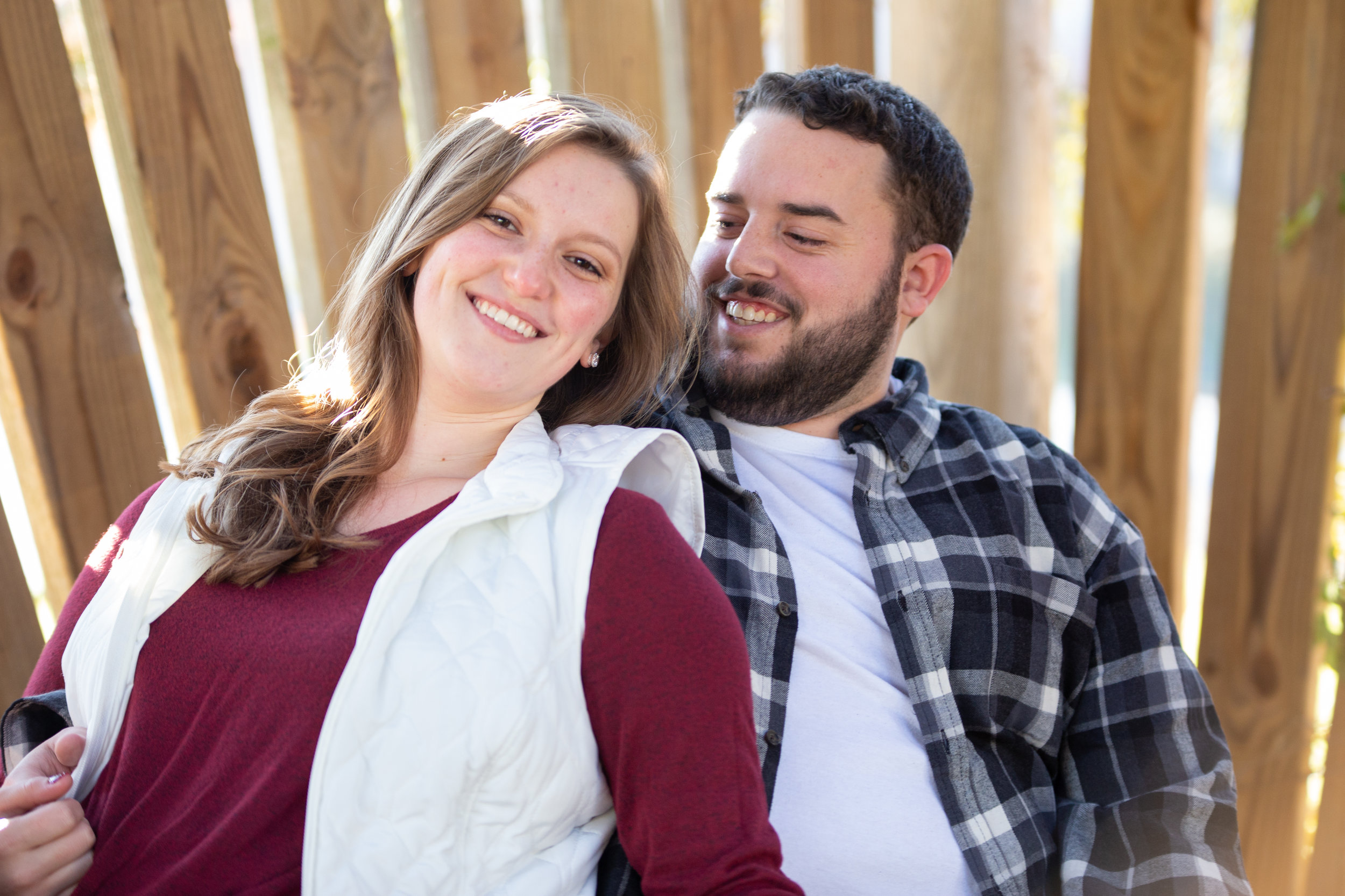 Fall-Vines-gaze-love-couple-shoot-photography-blacksburg-roanoke-love-lover-loving-engaged-wedding-Virginia-Tech-campus-slats-leaning-texture-smiling