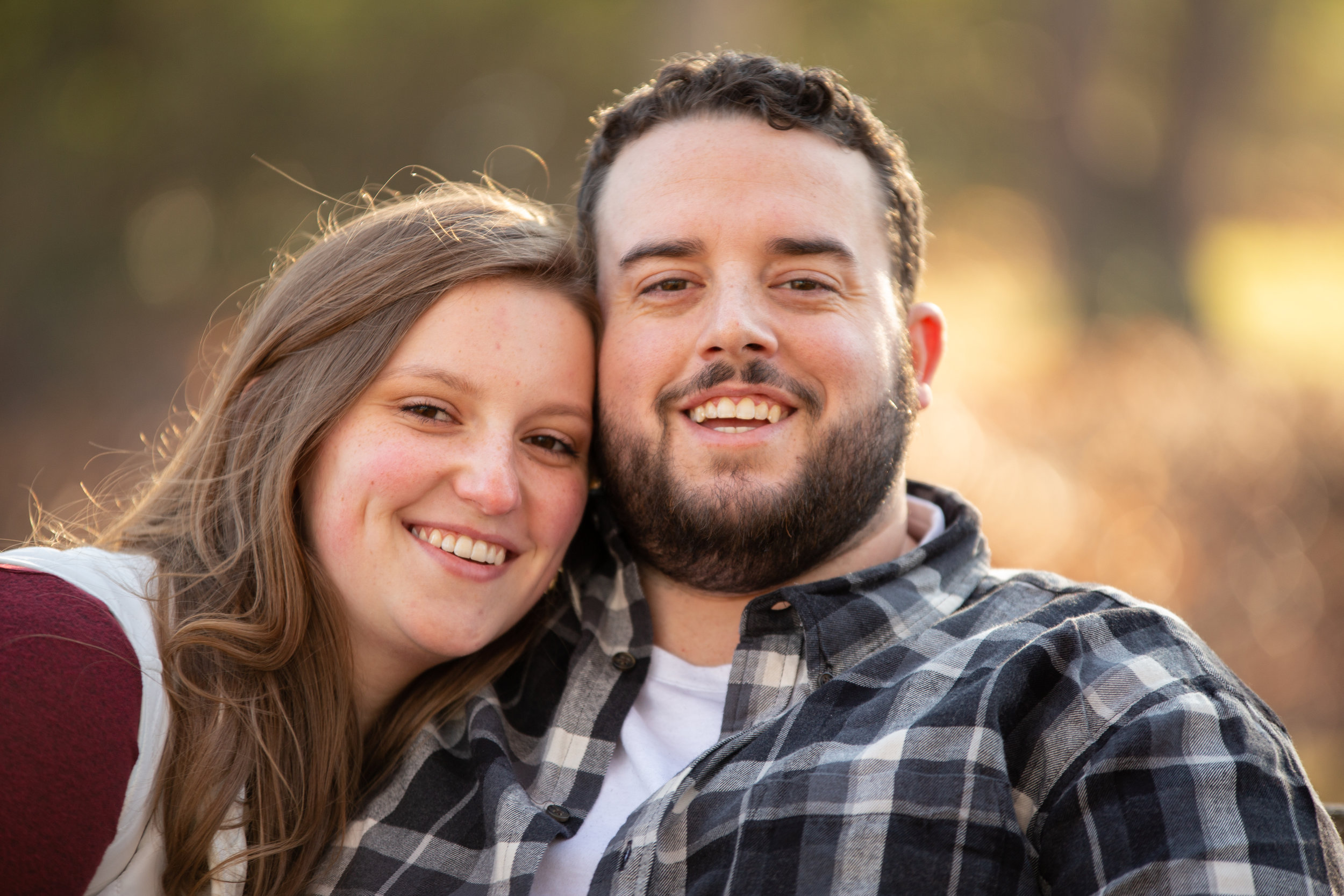 Fall-Laughing-together-bench-trees-duck-pond-virginia-tech-blacksburg-roanoke-engaged-warm-at camera-smiles-natural-candid