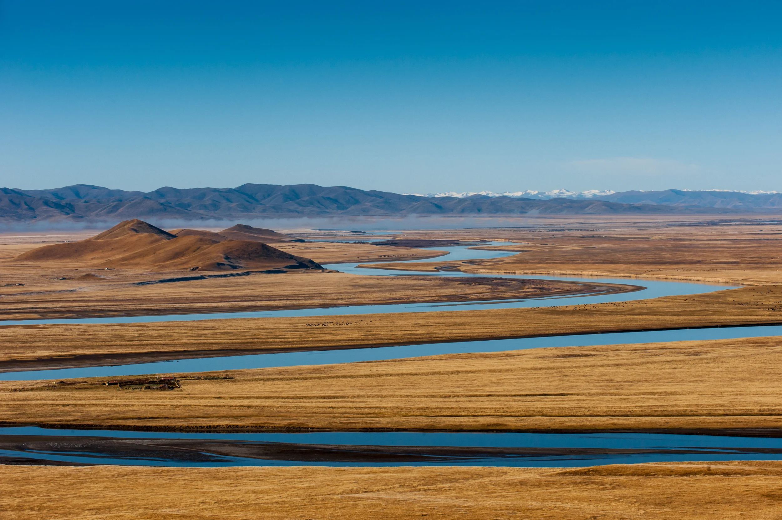 China At 5,464 kilometers, this is the second longest river in China (after the Yangtze) and the sixth-longest in the world. At sunrise the still water reflects the deep blue sky like a mirror. The tiny black specs on the grasslands are Yaks grazing.