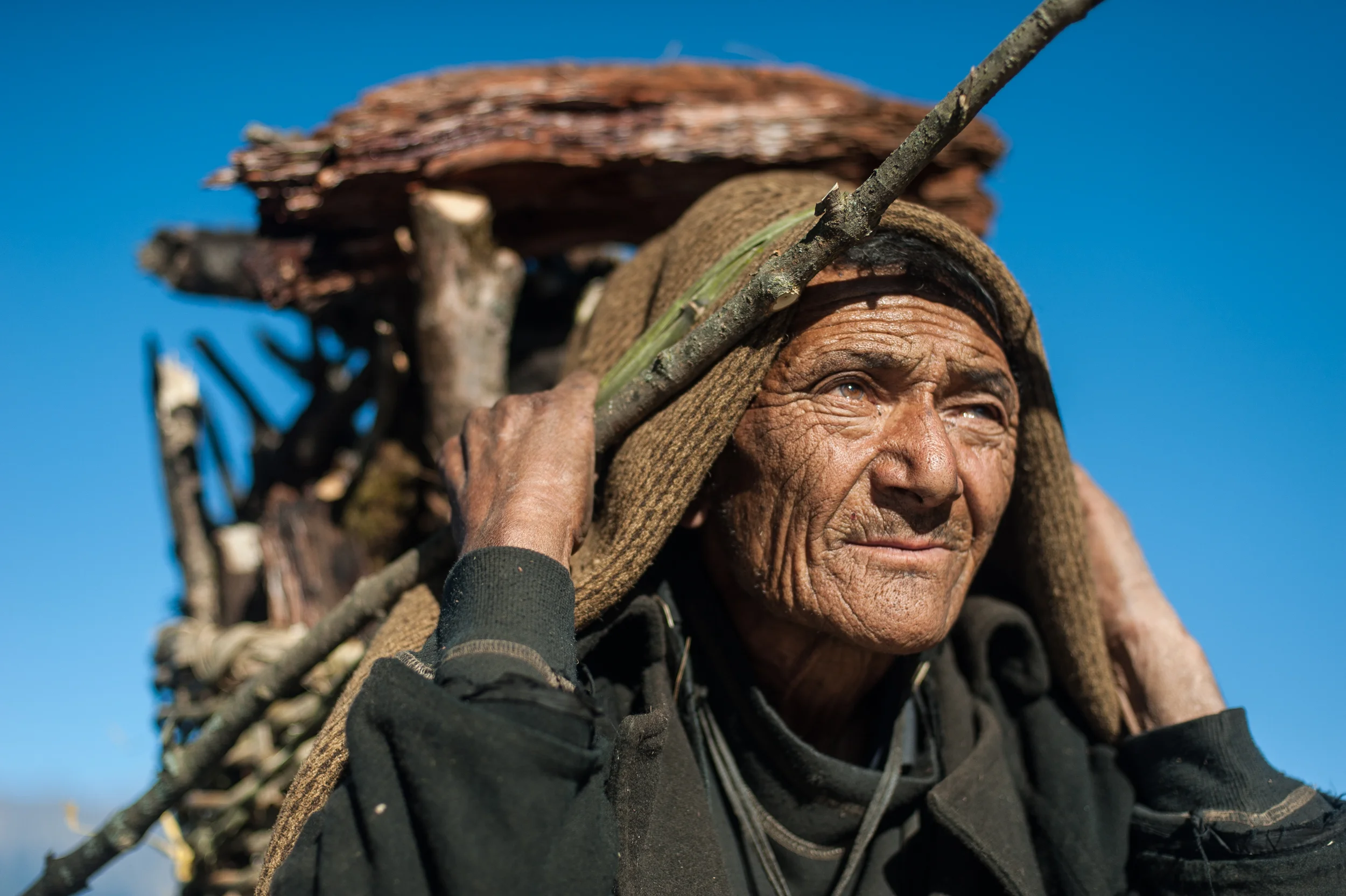 Nepal An elderly Gurung man from the Manaslu region in Nepal carries firewood.