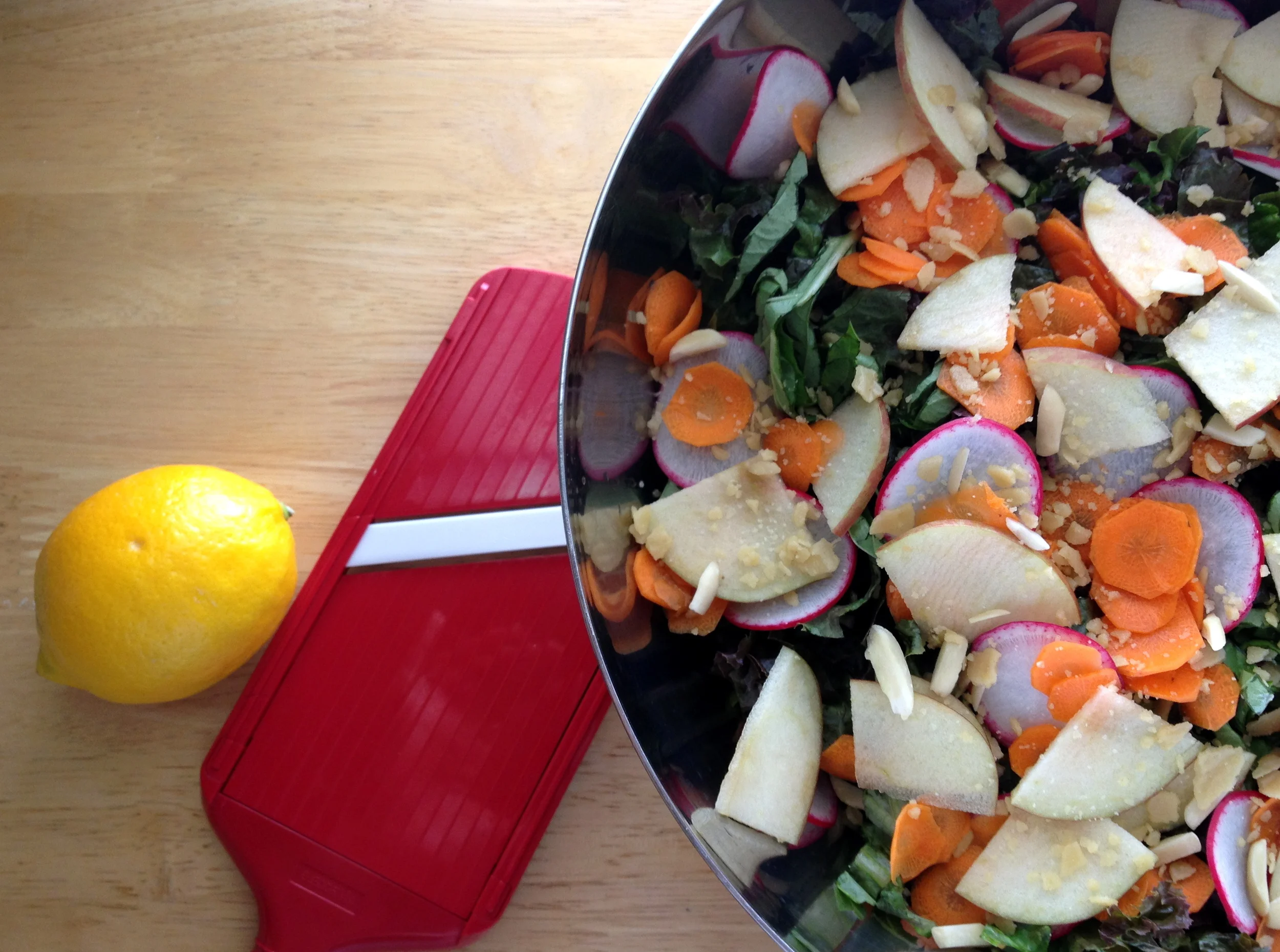 Salad with sliced carrot, pear, and radish topped with pine nut parmesan. 