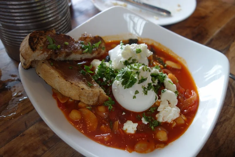 Poached egg, harissa piperade, braised garbanzos, chard, date toast at M.B. Post | Foodable WebTV Network