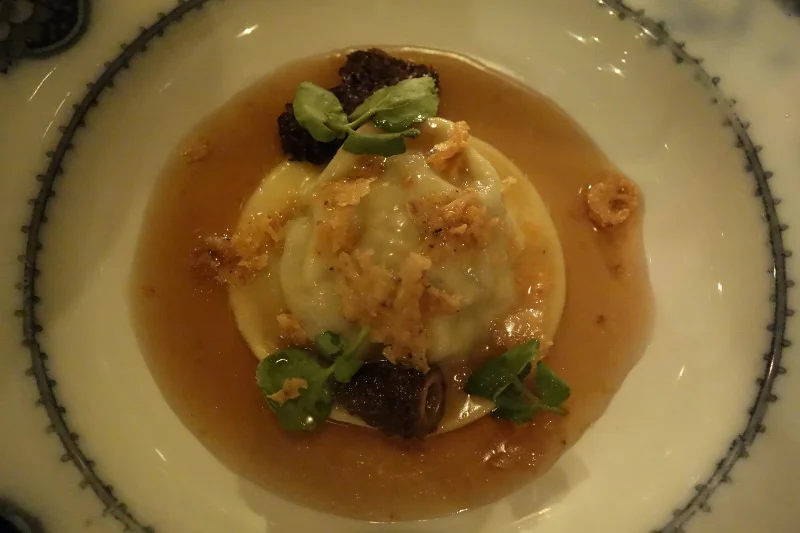 Raviolo with consommé, truffle crumble, and watercress at Maude | FOODABLE WEBTV NETWORK